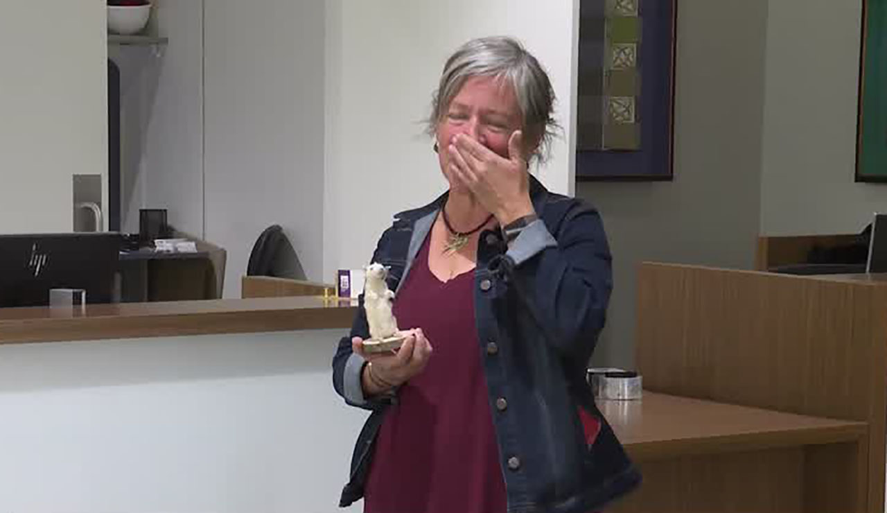 Carrie Poulsen is reunited with her taxidermy rat at Salt Lake City International Airport, Monday.