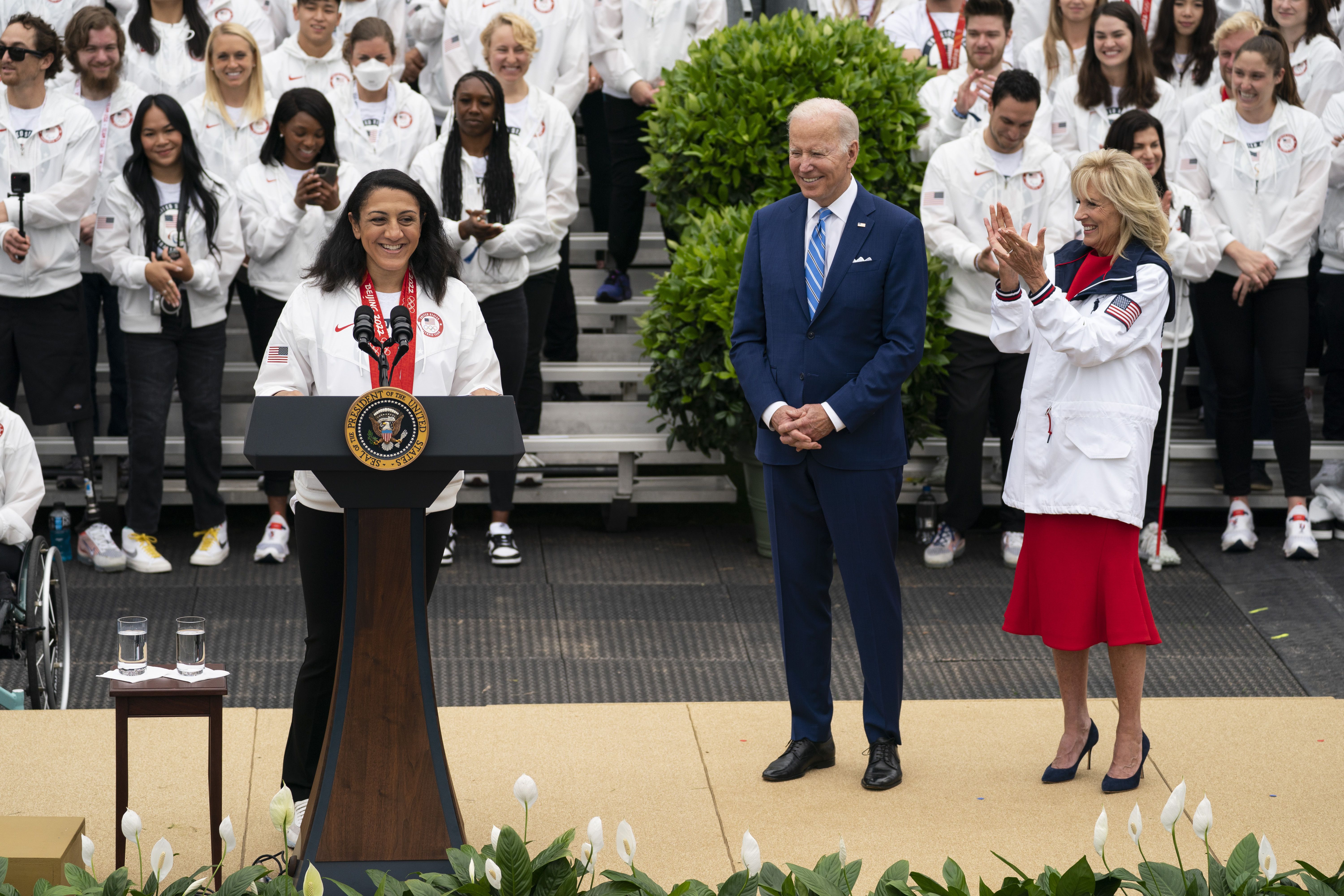 President Joe Biden and first lady Jill Biden listen as bobsledder Elana Meyers Taylor speaks during an event with the Tokyo 2020 Summer Olympic and Paralympic Games, and Beijing 2022 Winter Olympic and Paralympic Games, on the South Lawn of the White House, Wednesday, in Washington.