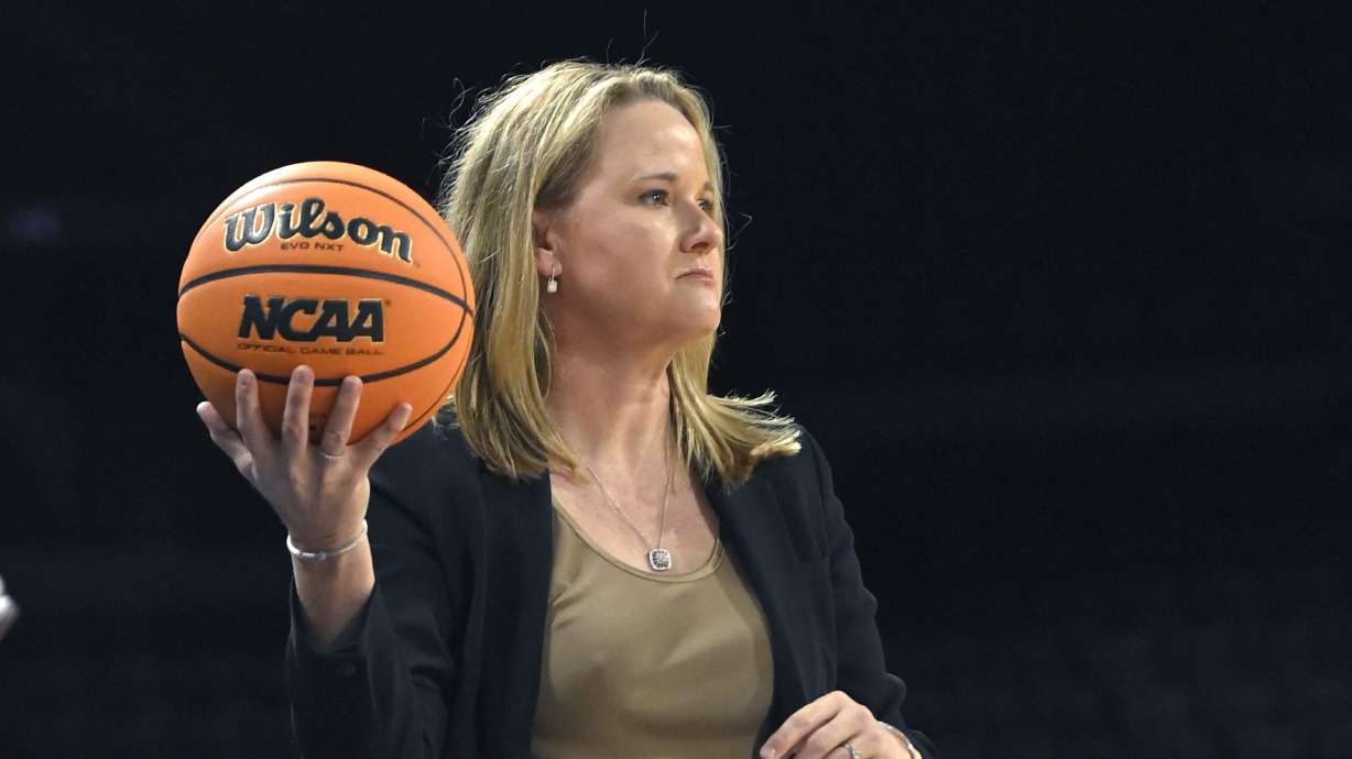 Utah head coach Lynne Roberts holds the game ball during the fist half of an NCAA college basketball game Washington State in the quarterfinals of the Pac-12 women's tournament Thursday, March 3, 2022, in Las Vegas.