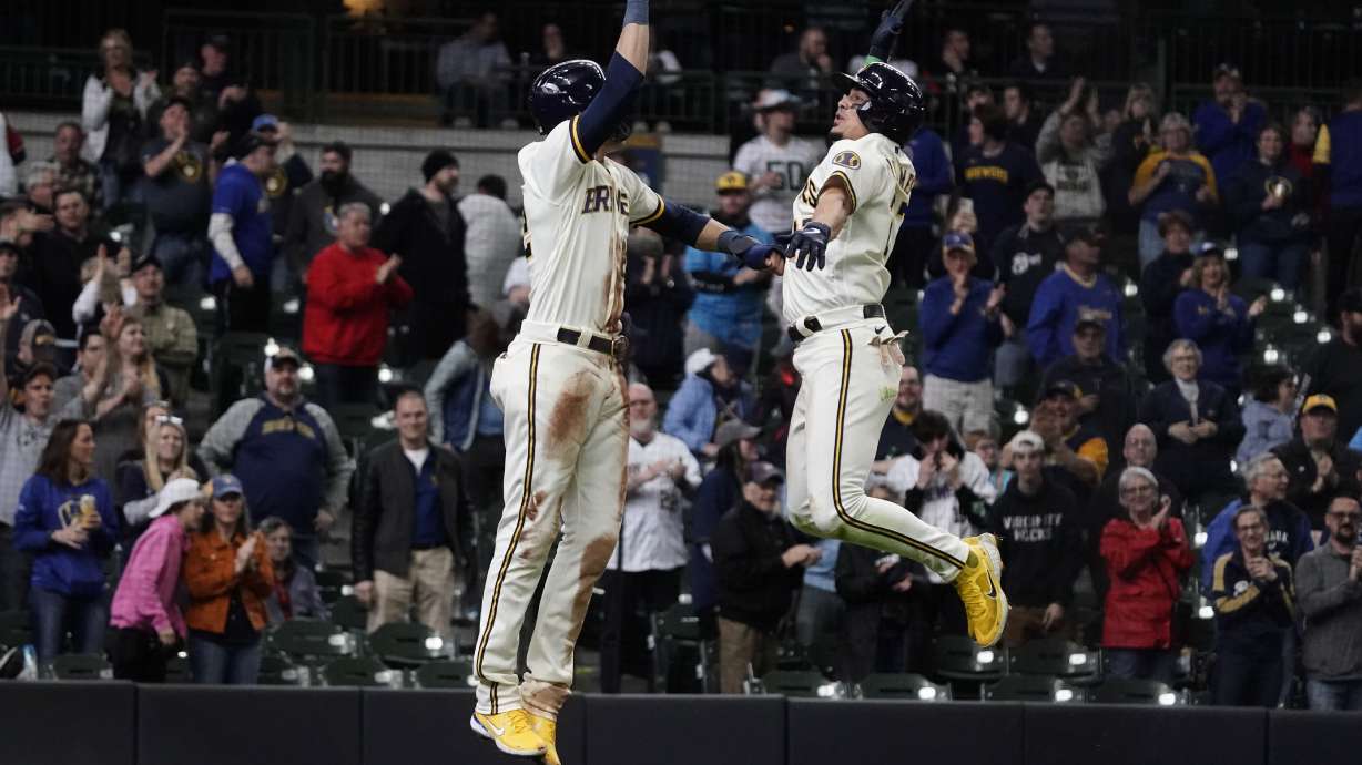 Milwaukee Brewers' Willy Adames celebrates with Christian Yelich after hitting a two-run home run during the eighth inning of a baseball game against the Cincinnati Reds Thursday, May 5, 2022, in Milwaukee.