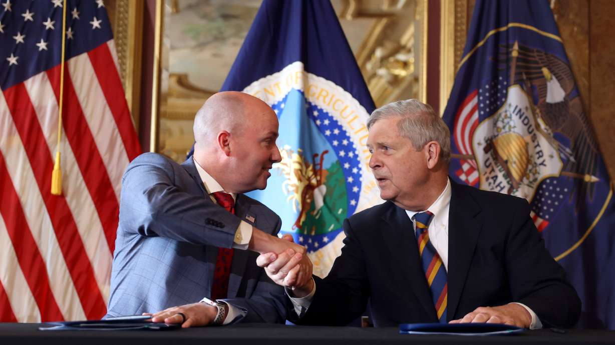 Gov. Spencer Cox, left, and Tom Vilsack, U.S. agriculture secretary, shake hands after signing the renewed Shared Stewardship agreement at the Capitol in Salt Lake City on Thursday.