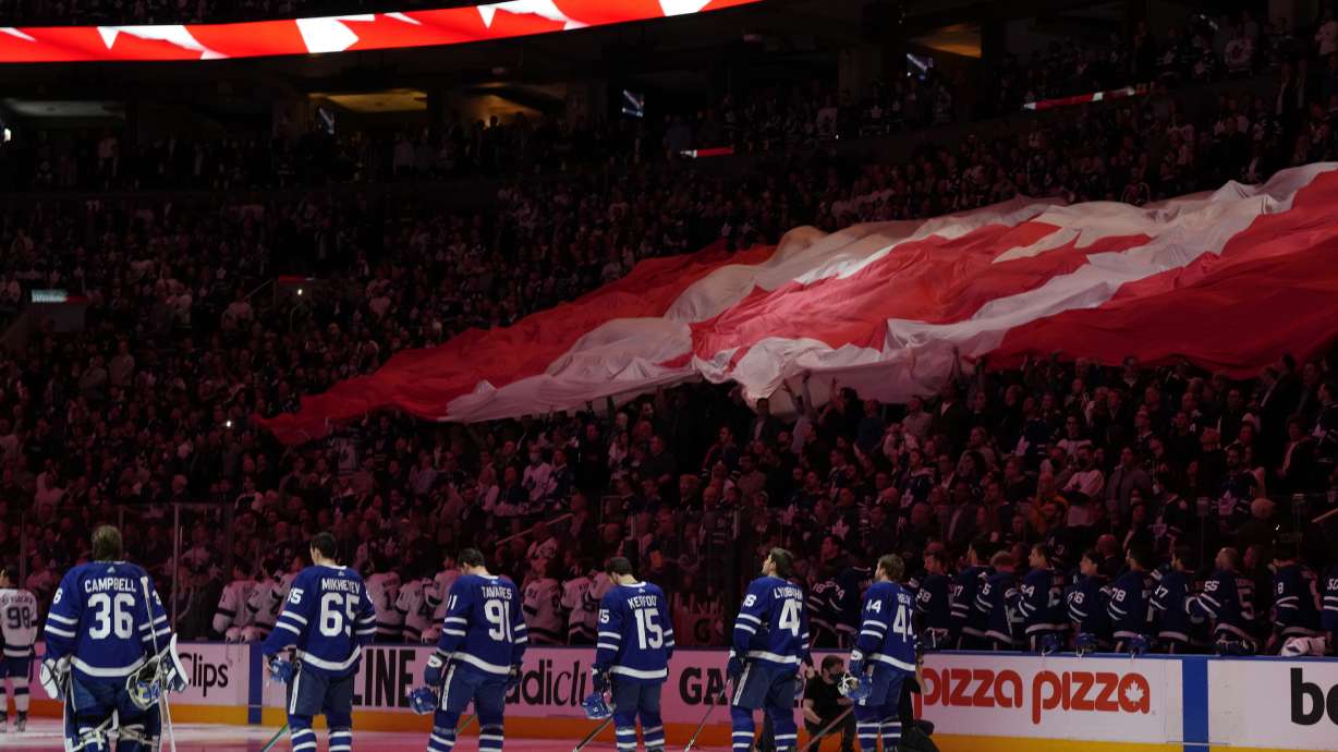 Fans and players stand for the national anthems before Game 2 of an NHL hockey Stanley Cup playoffs first-round series between the Tampa Bay Lightning and the Toronto Maple Leafs on Wednesday, May 4, 2022, in Toronto.