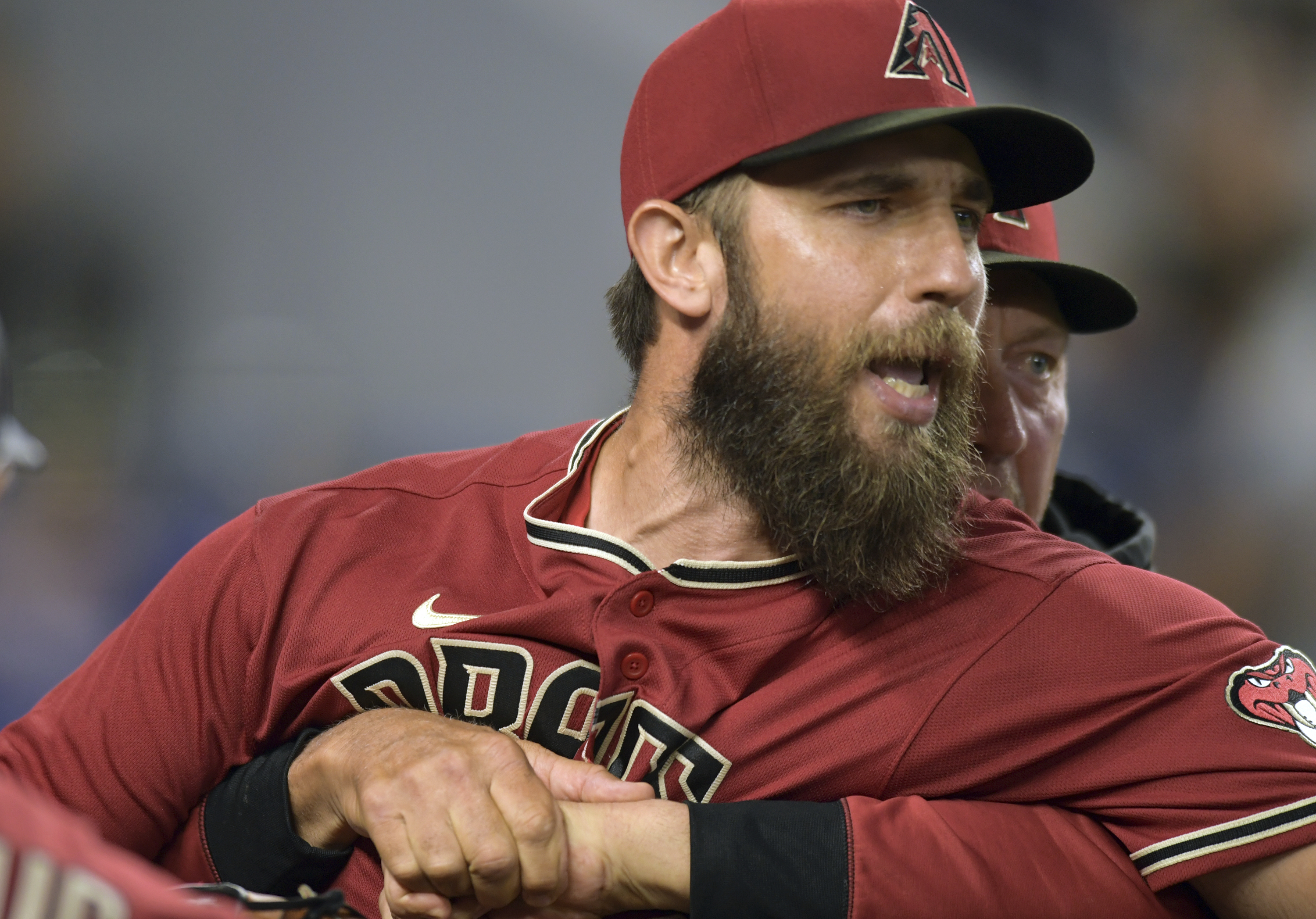 Arizona Diamondbacks' pitcher Madison Bumgarner, left, is restrained by bench coach Jeff Banister while arguing with umpires after the first inning of a baseball game against the against the Miami Marlins, Wednesday, May 4, 2022, in Miami. 