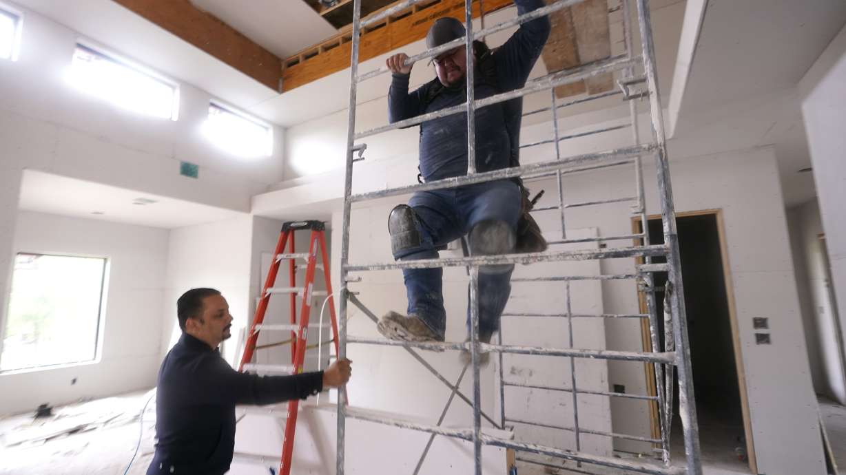 Joshua Correa, left, steadies a scaffolding for Samuel as they work at a home under construction in Plano, Texas, on May 3. There are an estimated 2 million fewer immigrants than expected in the United States, helping fuel a desperate scramble for workers in many sectors that is also contributing to shortages and price increases.