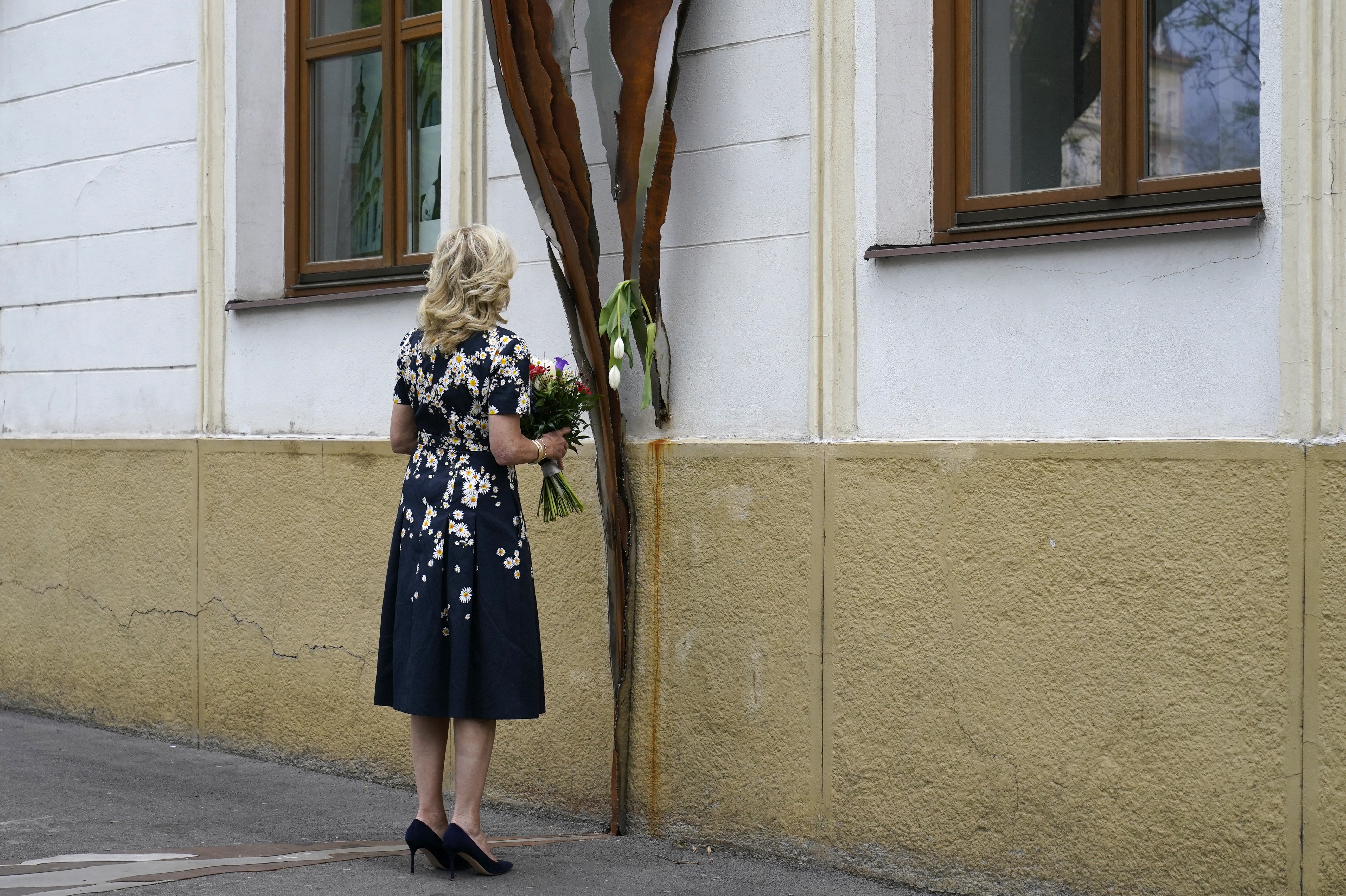 First lady Jill Biden pauses as she places flowers at memorial in Bratislava, Slovakia, Saturday that is dedicated to the 26-year-old investigative journalist Jan Kuciak and his fiancée Martina Kusnirova, who were assassinated in their home in 2018. Kuciak had been investigating possible government corruption when he was killed. The killings prompted major street protests unseen since the 1989 Velvet Revolution in Czechoslovakia and a political crisis that led to the government's collapse.