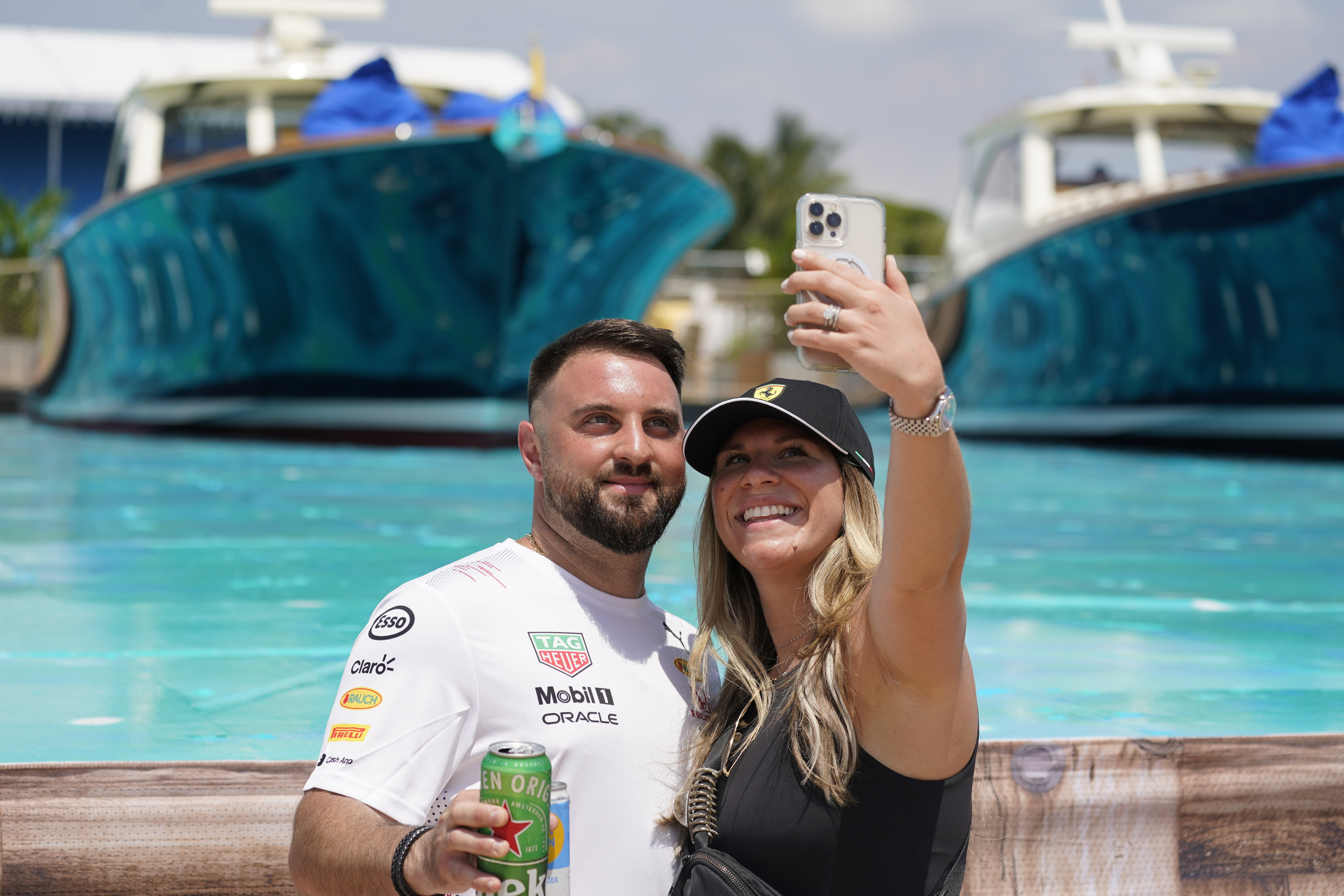 Marc and Isabella pose for a selfie at the man-made marina and beach club during the Formula One Miami Grand Prix auto race at Miami International Autodrome, Friday, May 6, 2022, in Miami Gardens, Fla.