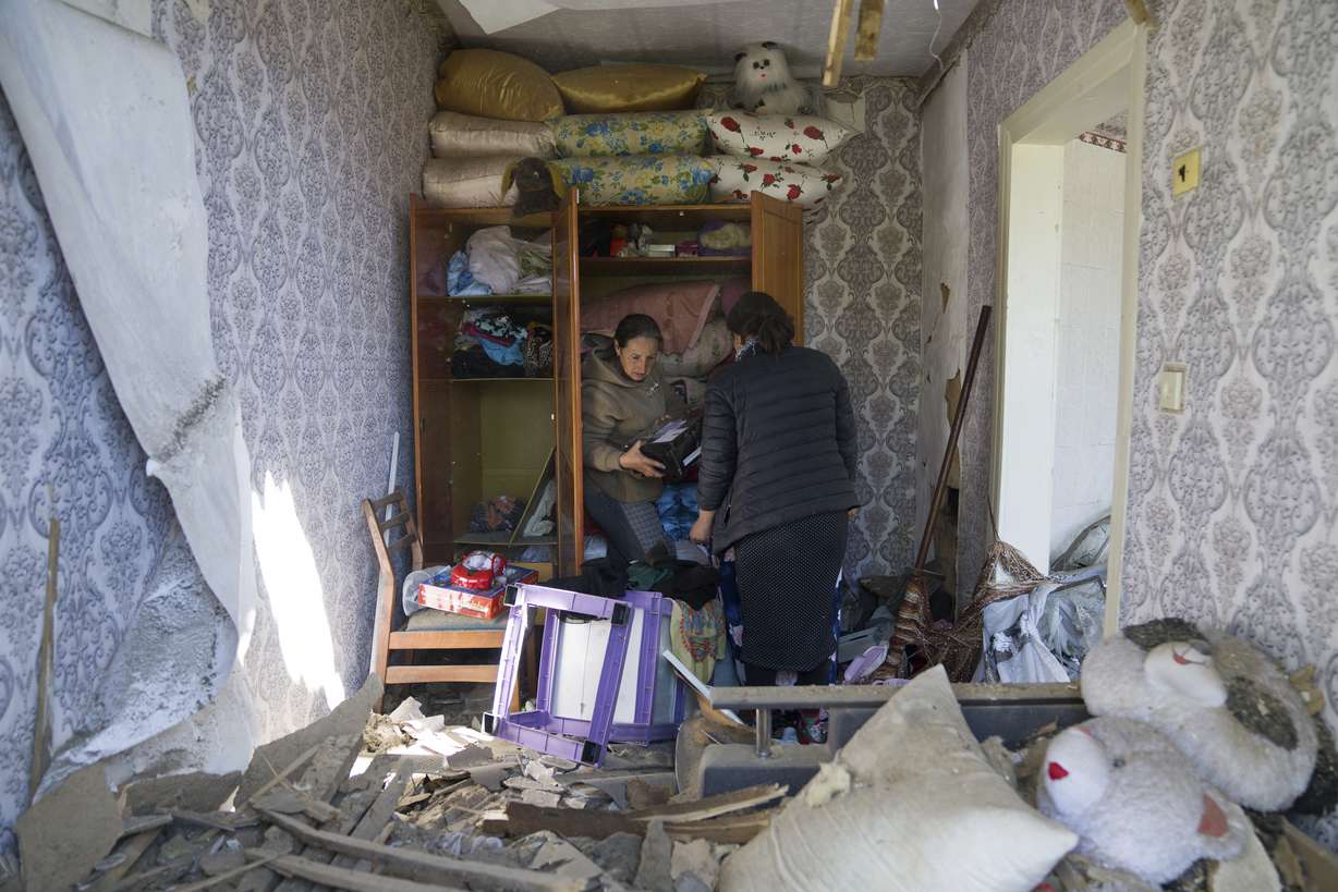 Women collect belongings in their apartment destroyed by Russian airstrike in Bakhmut, Donetsk region, Ukraine, Saturday.