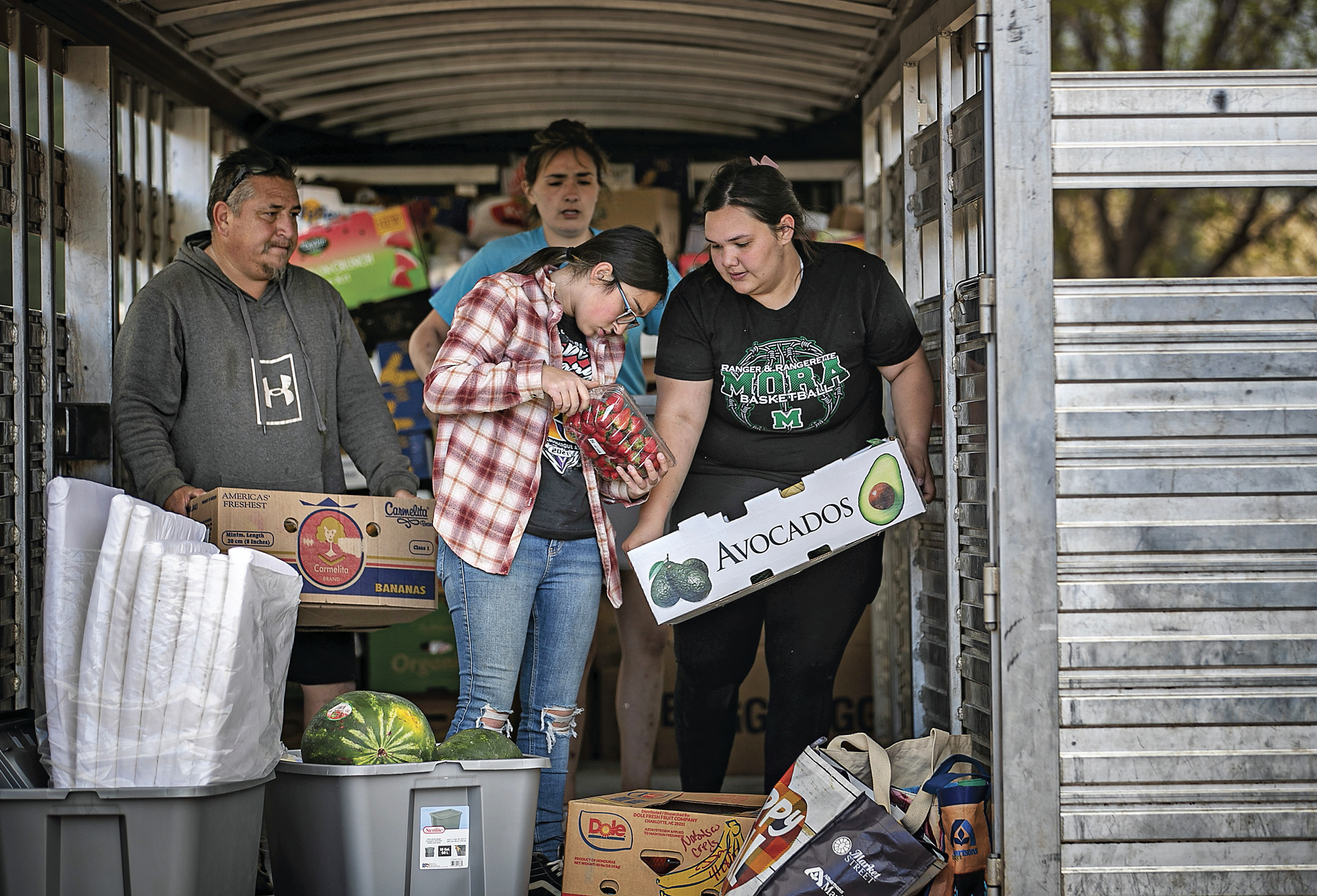 Gabriella Duran, far right, and local volunteers at the Mora Head Start building, help sort through food donated to families choosing to remain in Mora, N.M., on Wednesday where firefighters have been battling the Hermit's Peak and Calf Canyon fire for weeks. Weather conditions described as potentially historic are on tap for New Mexico on Saturday and over the next several days as the largest fire burning in the U.S. chews through more tinder-dry mountainsides.