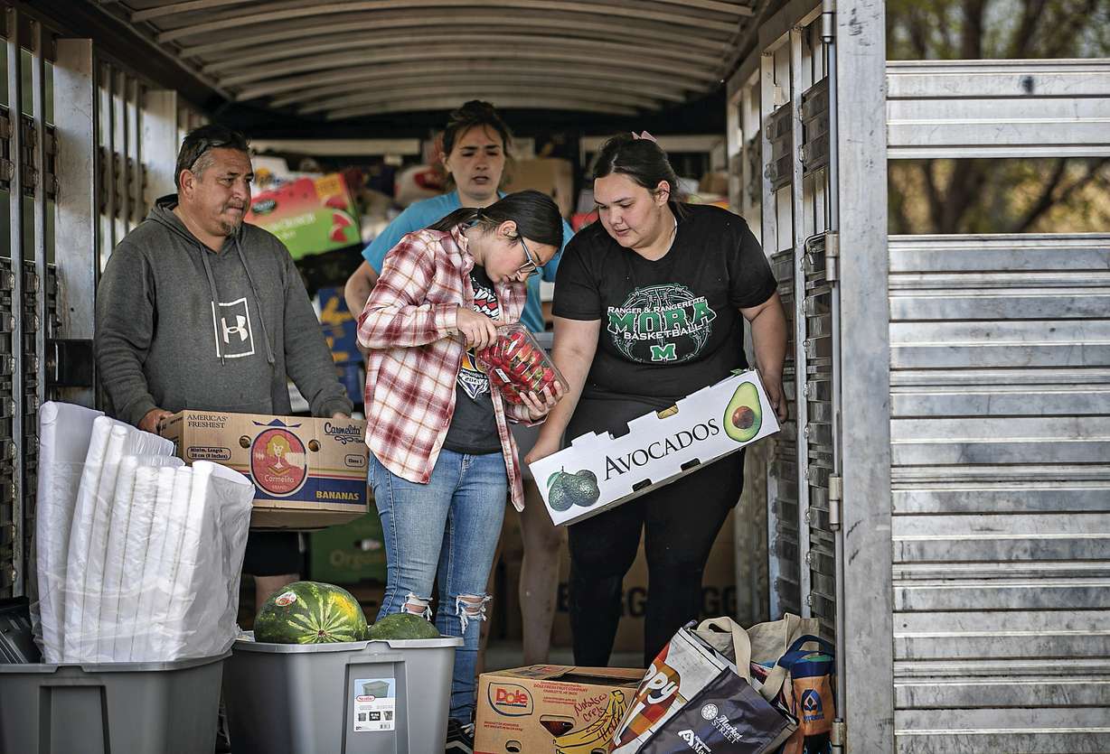 Gabriella Duran, far right, and local volunteers at the Mora Head Start building, help sort through food donated to families choosing to remain in Mora, N.M., on Wednesday where firefighters have been battling the Hermit's Peak and Calf Canyon fire for weeks. Weather conditions described as potentially historic are on tap for New Mexico on Saturday and over the next several days as the largest fire burning in the U.S. chews through more tinder-dry mountainsides.
