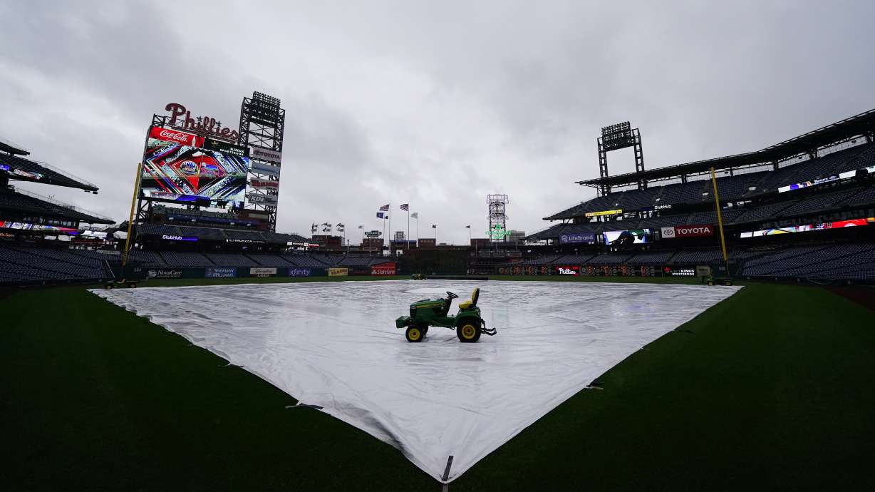 A tarp is seen covering the field as a storm postpones a baseball game between the Philadelphia Phillies and the New York Mets, Saturday, May 7, 2022, in Philadelphia.