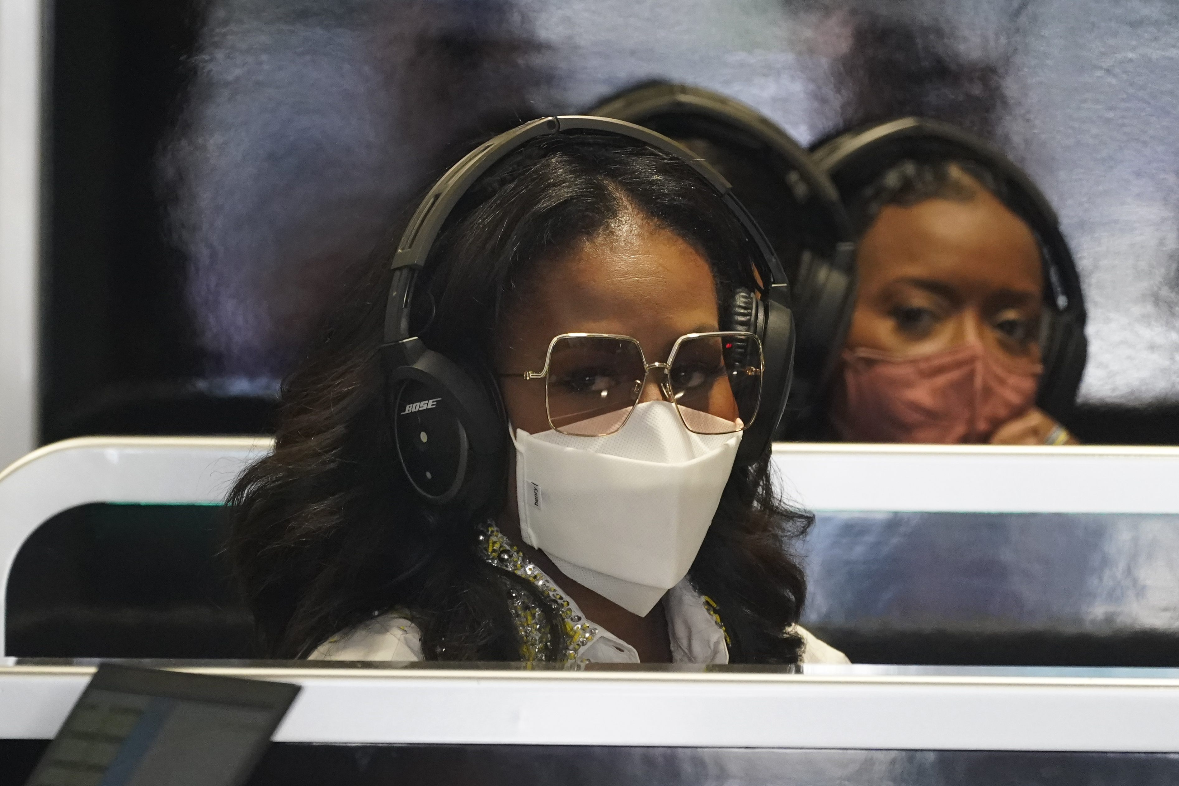 Former First Lady Michelle Obama, left, sits in the Mercedes team garage before the third practice session for the Formula One Miami Grand Prix auto race at the Miami International Autodrome, Saturday, May 7, 2022, in Miami Gardens, Fla. 