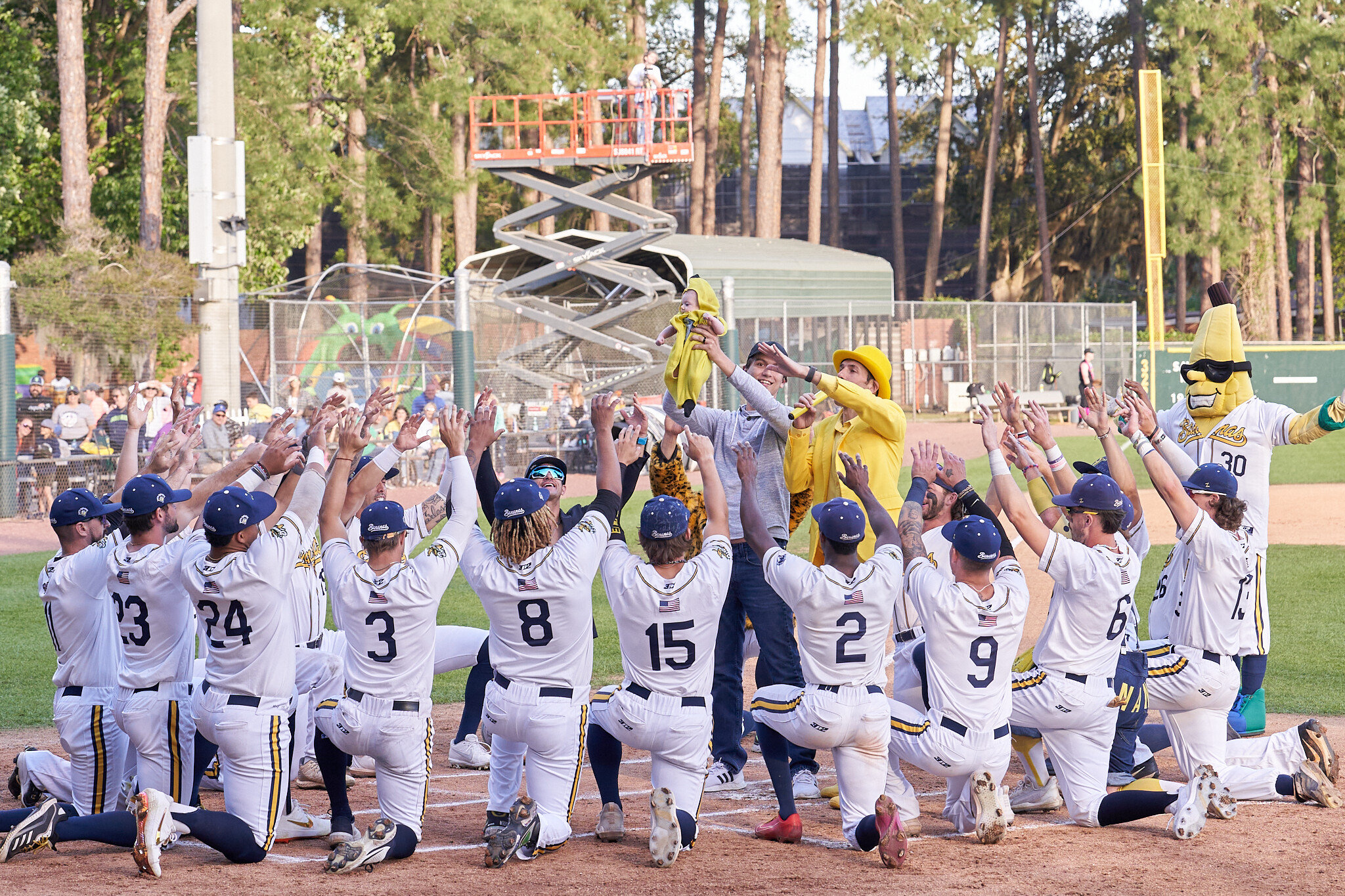 Players salute a baby dressed as a banana (as one does) before a game.