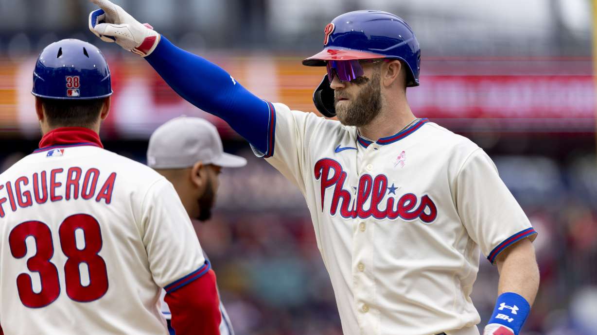 Philadelphia Phillies' Bryce Harper (3) gestures from first base after hitting an RBI single during the third inning of the first game of a double header against the New York Mets, Sunday, May 8, 2022, in Philadelphia.