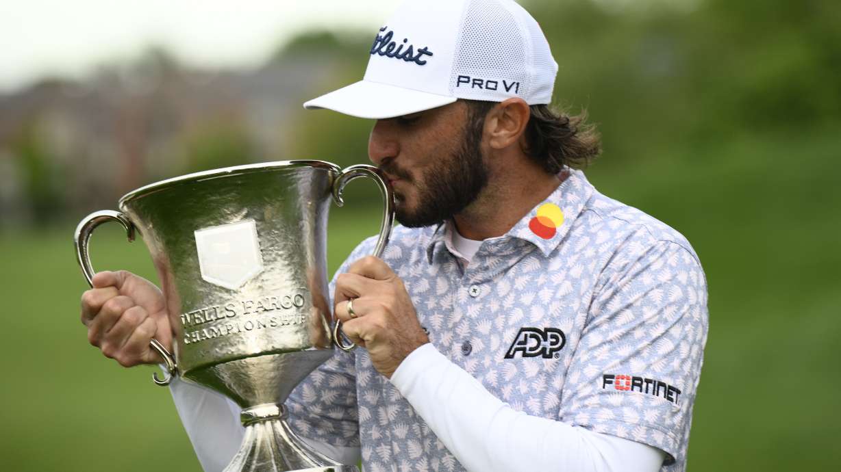 Max Homa kisses the trophy after winning the Wells Fargo Championship golf tournament, Sunday, May 8, 2022, at TPC Potomac at Avenel Farm golf club in Potomac, Md.