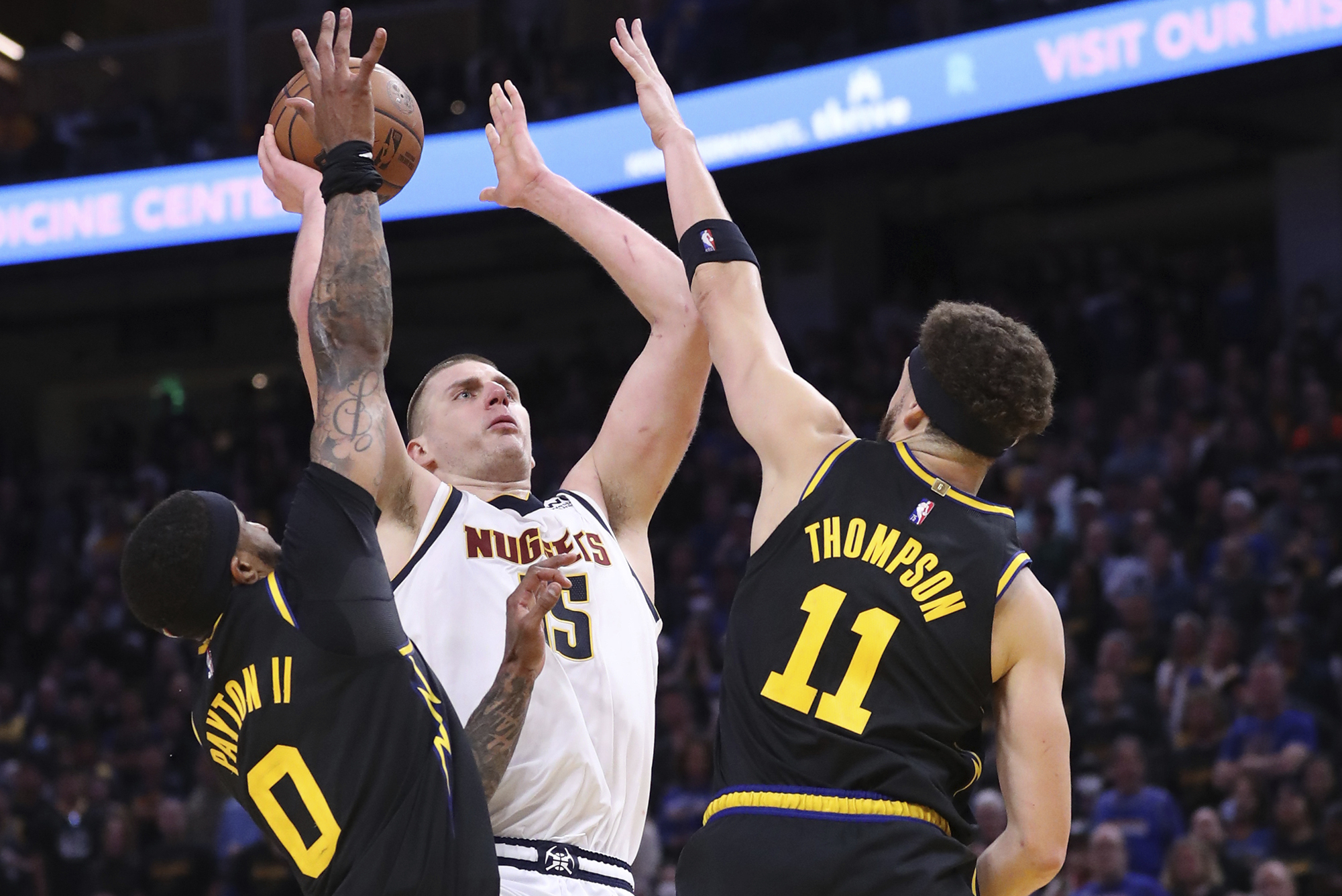 Golden State Warriors' Gary Payton II and Klay Thompson guard Denver Nuggets' Nikola Jokic in 4th quarter during Warriors' 102-98 win in Game 5 of NBA Western Conference First Round playoff game at Chase Center in San Francisco, Calif, on Wednesday, April 27, 2022.