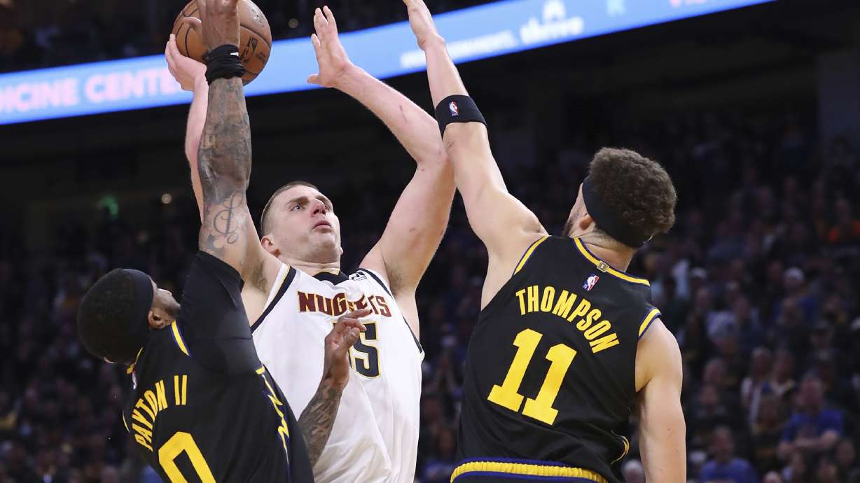 Golden State Warriors' Gary Payton II and Klay Thompson guard Denver Nuggets' Nikola Jokic in 4th quarter during Warriors' 102-98 win in Game 5 of NBA Western Conference First Round playoff game at Chase Center in San Francisco, Calif, on Wednesday, April 27, 2022.