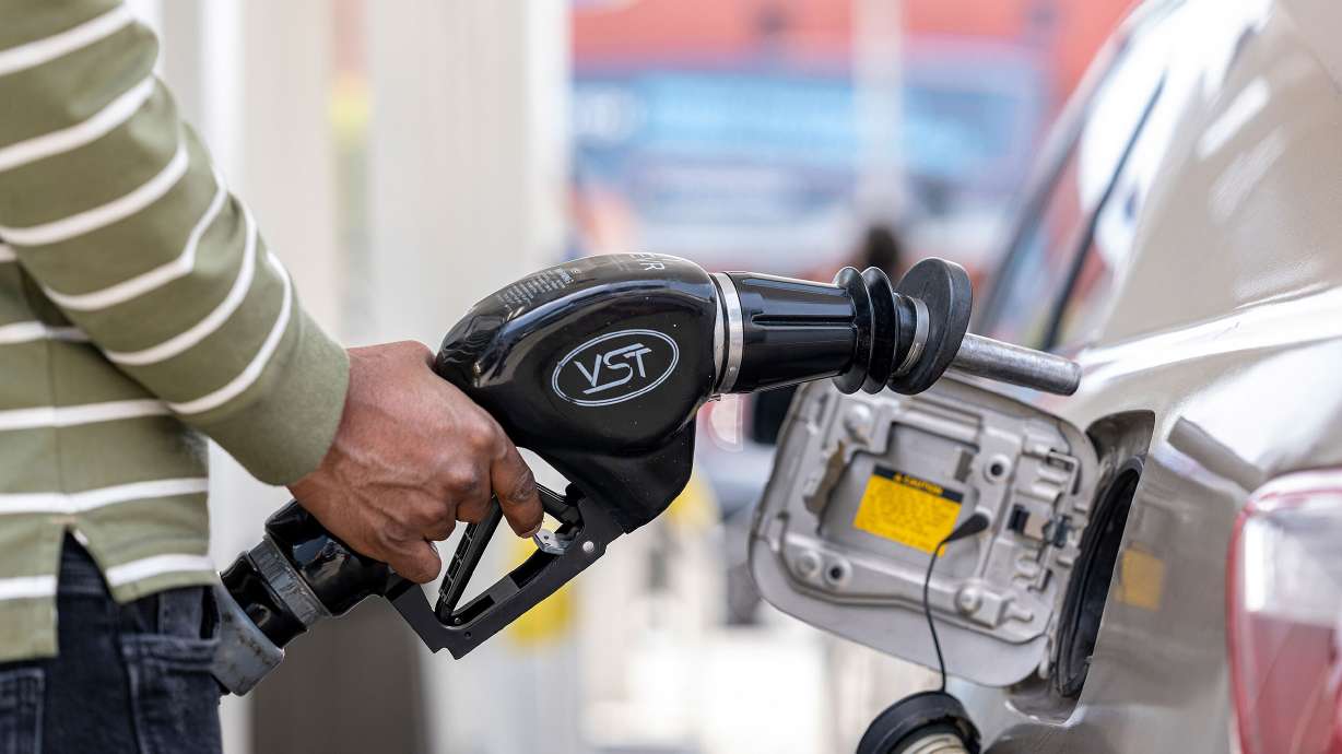 A customer holds a fuel nozzle at a gas station in San Francisco on April 27. According to AAA, the national average for regular gasoline has risen to $4.328 a gallon.