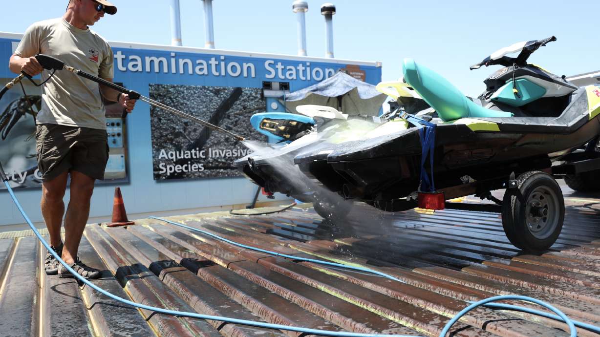 A Utah Division of Wildlife Resources employee sprays down a watercraft for quagga mussels at a state inspection station on Sept. 9, 2020. The division said Monday it is dealing with staff shortages for inspections, which is why it is turning to Wyoming for help.