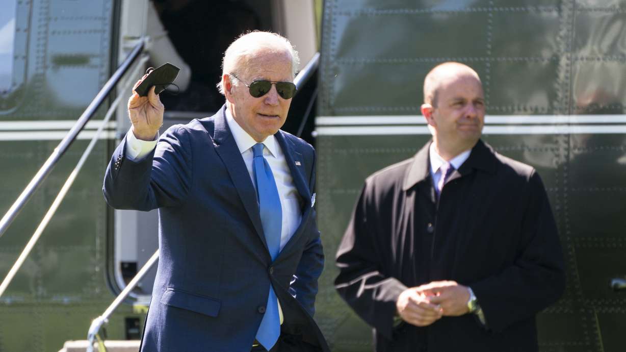 President Joe Biden waves as he walks past a U.S. Secret Service agent upon arrival at the White House from a weekend trip to his Delaware home, Monday, May 9, 2022, in Washington.