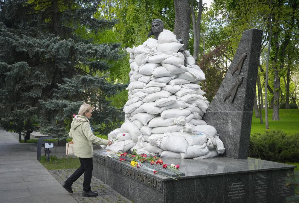 A woman lays flowers at the Unknown Soldier Tomb, protected by sandbags, on the occasion of the Victory Day in World War II, in Kyiv, Ukraine, Monday. Russian President Vladimir Putin marked his country's biggest patriotic holiday Monday without a major new battlefield success in Ukraine.