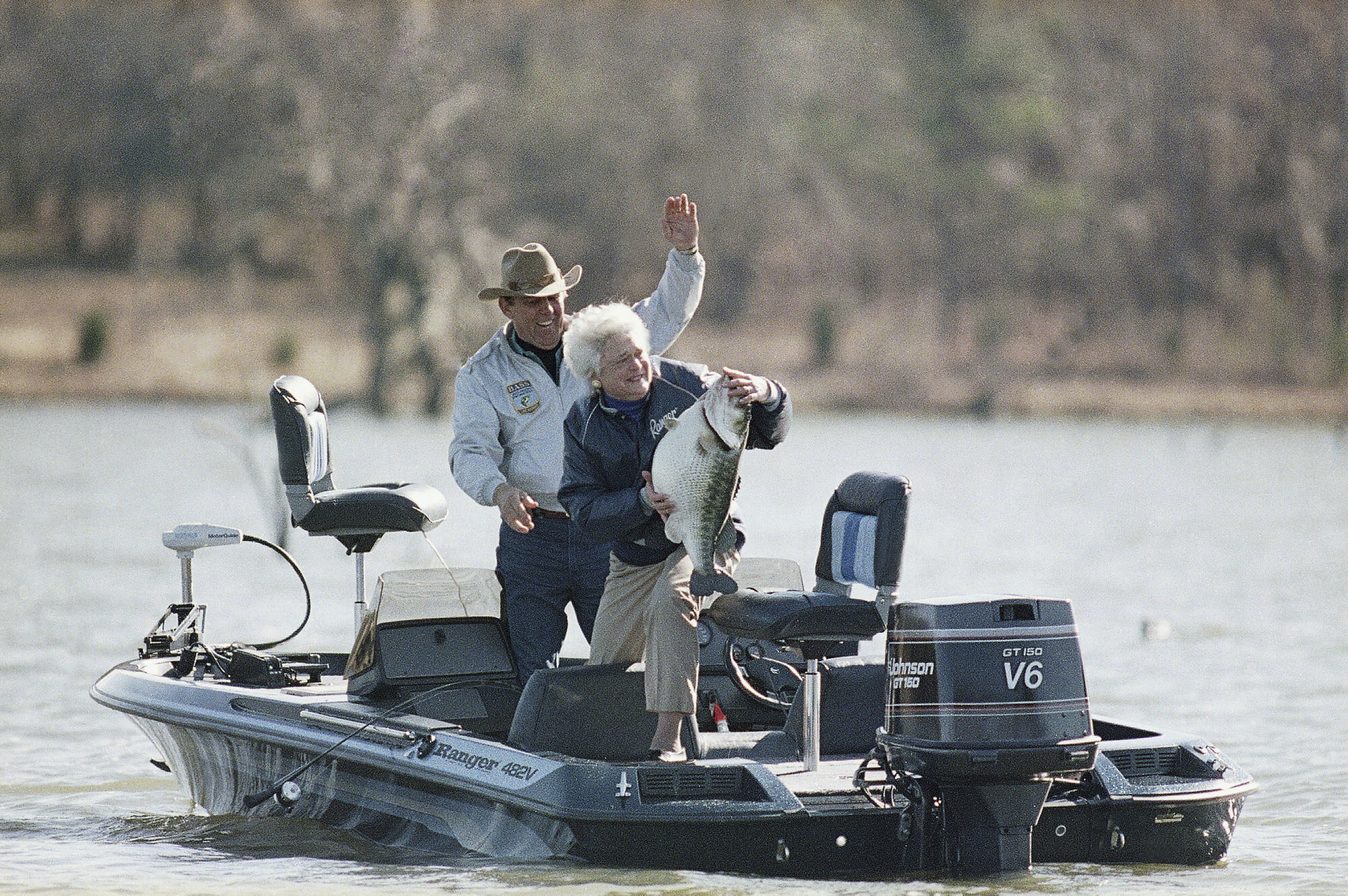 FILE - First lady Barbara Bush holds a mounted bass as a joke with fishing partner Ray Scott at his lake in Pintlala, Ala., on Jan. 1, 1990. A longtime aide said Scott died on Sunday, May 8, 2022, at the age of 88. 