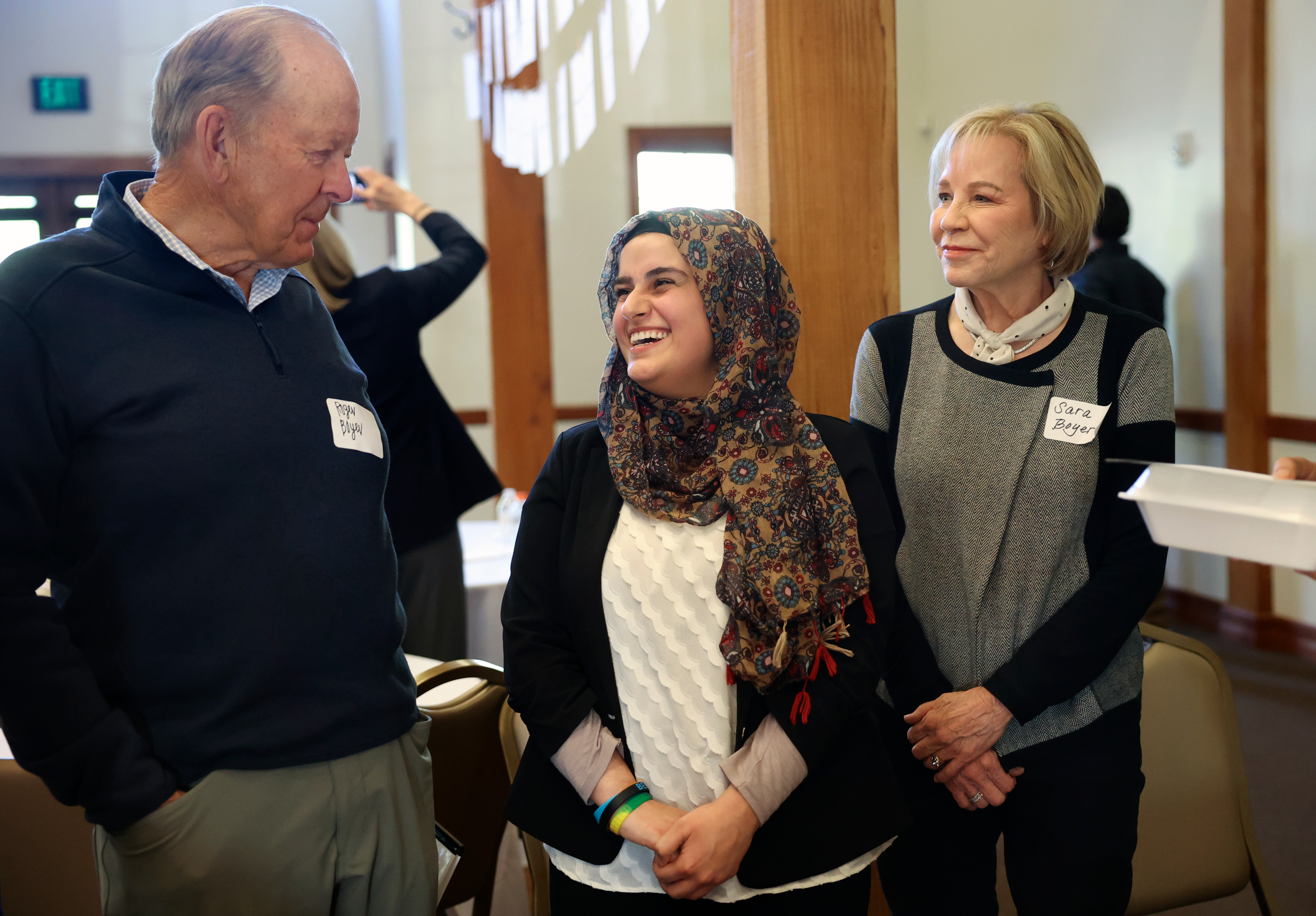 One Refugee founders Roger Boyer and Sara Boyer talk with One Refugee graduate Sarah Shwani, center, who completed her pharmacy prerequisites at Utah Valley University, during the One Refugee Annual Celebration, to honor 64 college graduates who are also refugees, at the Garden Place in Salt Lake City on Monday.