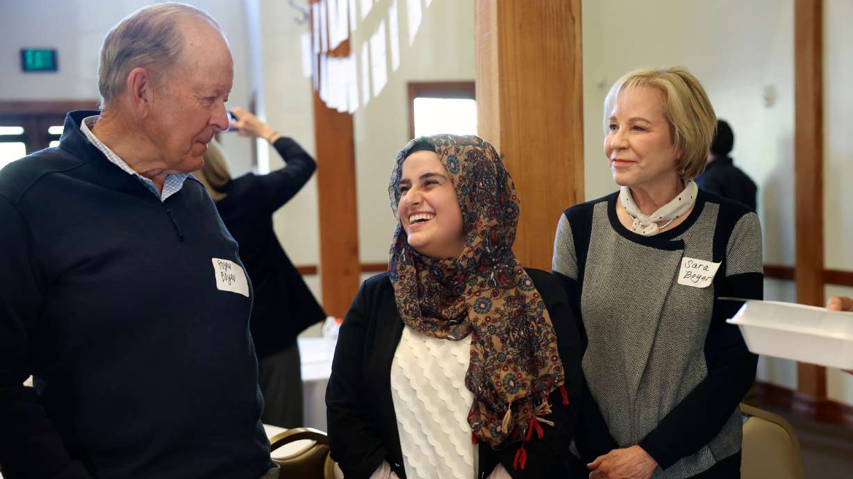 One Refugee founders Roger Boyer and Sara Boyer talk with One Refugee graduate Sarah Shwani, center, who completed her pharmacy prerequisites at Utah Valley University, during the One Refugee Annual Celebration, to honor 64 college graduates who are also refugees, at the Garden Place in Salt Lake City on Monday.