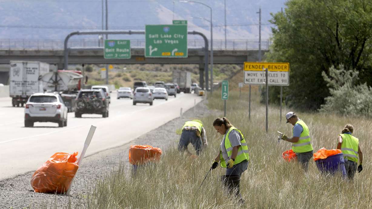 Cleanup crews contracted through the Utah Department of Transportation pick up litter and roadside debris along eastbound I-215 between Redwood Road and I-15 in Murray on Wednesday, June 30, 2021. UDOT reports litter cleanup calls are up 28% over the past five years.