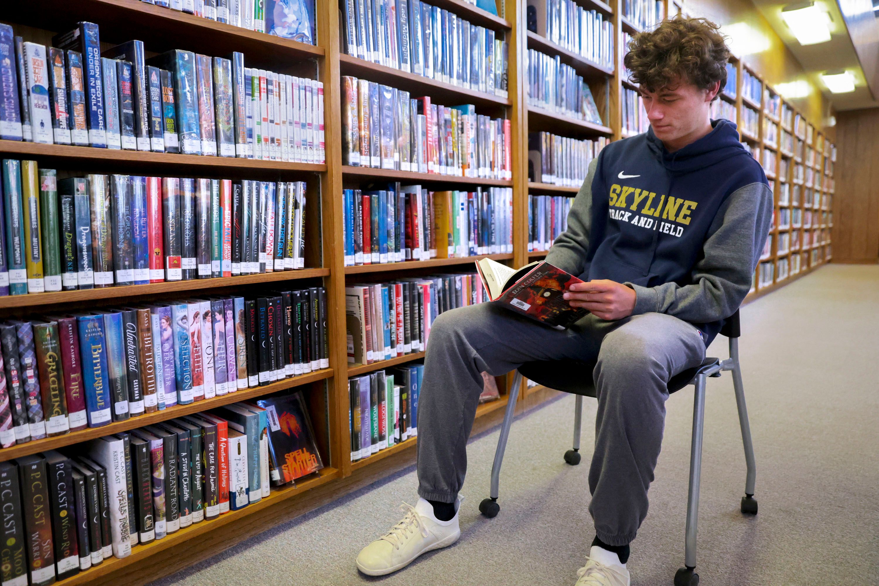 Henry Christiansen, a senior at Skyline High School, reads a book at the library at Skyline High School in Salt Lake City on Tuesday. The Utah State Board of Education is working on a policy intended to provide school boards with a framework to create or update library policies.