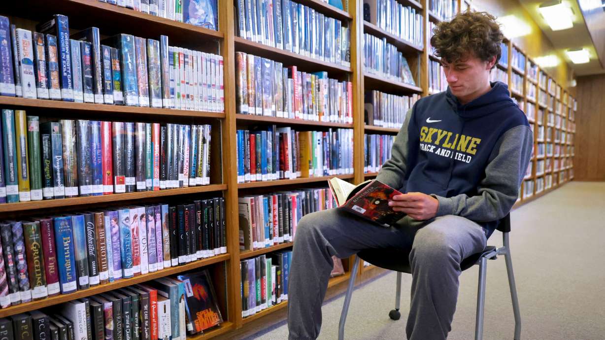 Henry Christiansen, a senior at Skyline High School, reads a book at the library at Skyline High School in Salt Lake City on Tuesday. The Utah State Board of Education is working on a policy intended to provide school boards with a framework to create or update library policies.