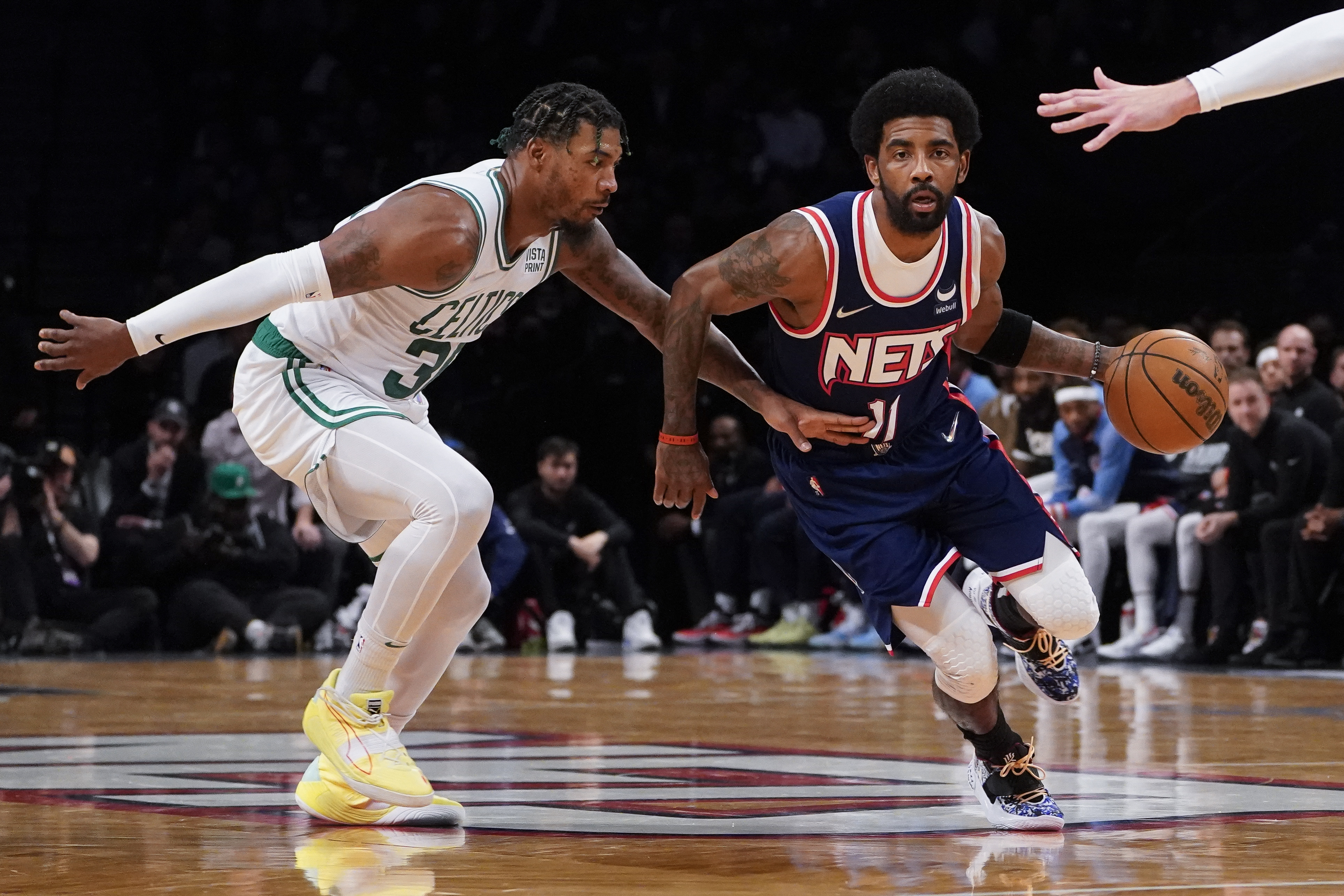 Brooklyn Nets guard Kyrie Irving (11) drives past Boston Celtics guard Marcus Smart, left, during the first half of Game 4 of an NBA basketball first-round playoff series, Monday, April 25, 2022, in New York. 