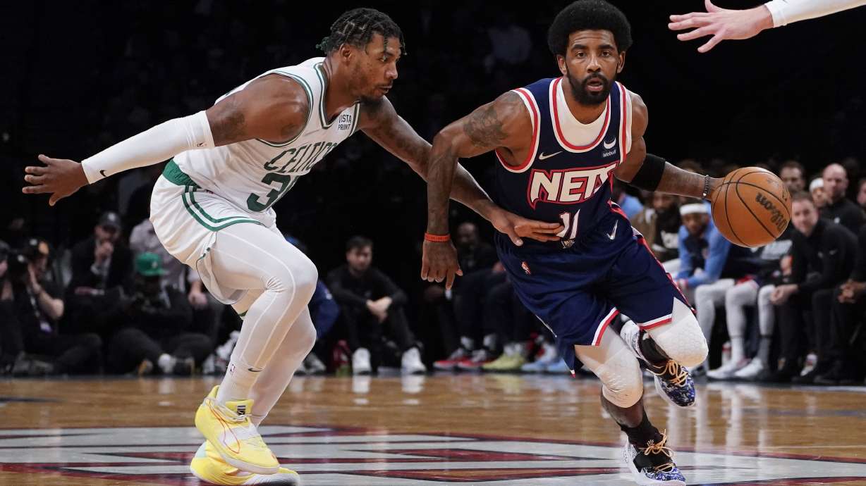 Brooklyn Nets guard Kyrie Irving (11) drives past Boston Celtics guard Marcus Smart, left, during the first half of Game 4 of an NBA basketball first-round playoff series, Monday, April 25, 2022, in New York.