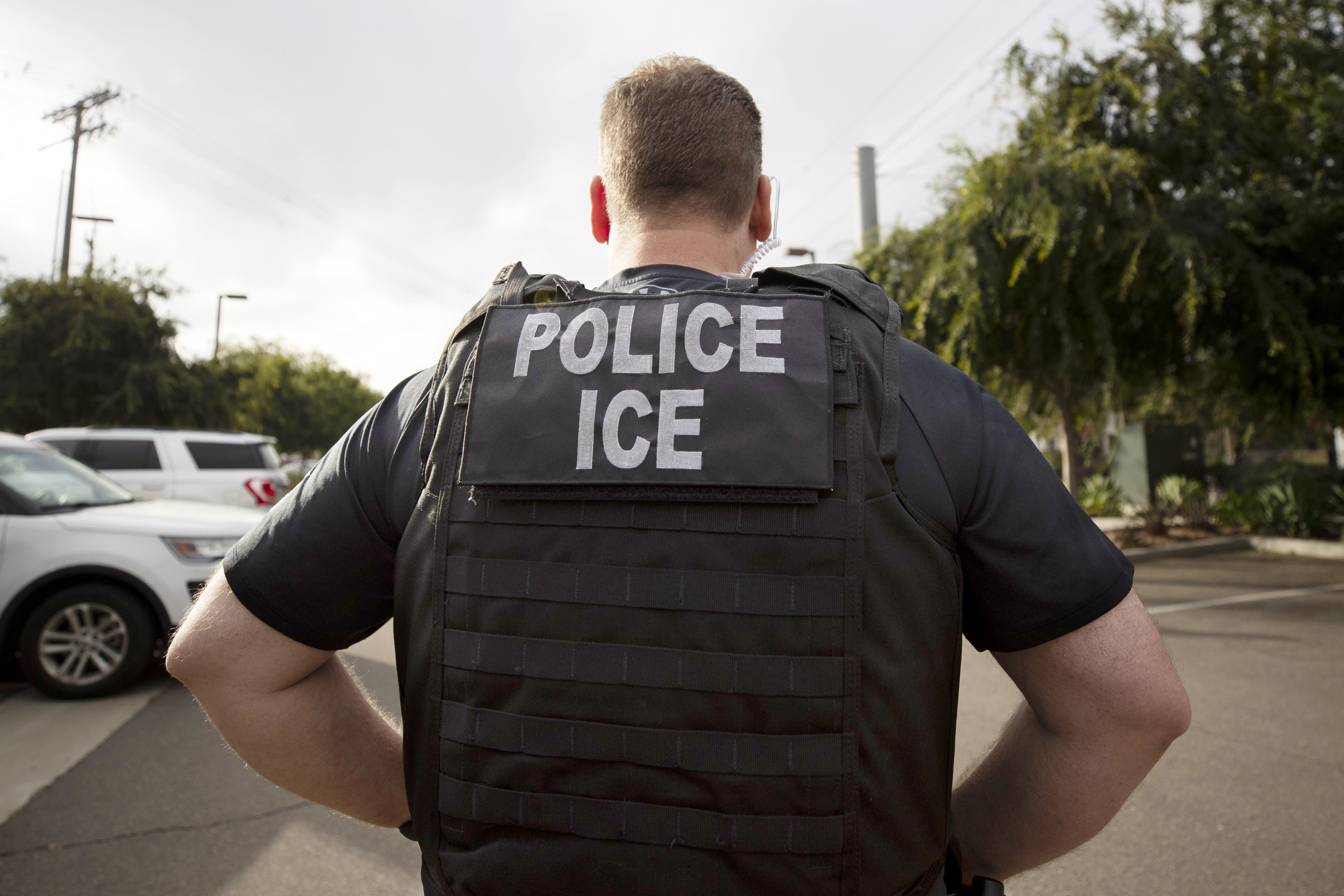 A U.S. Immigration and Customs Enforcement officer looks on during an operation in Escondido, Calif., July 8, 2019. The agency has what researchers call a "dragnet" surveillance system, compiling personal data and tracking the habits of 75% of Americans in attempt to deport undocumented people. 