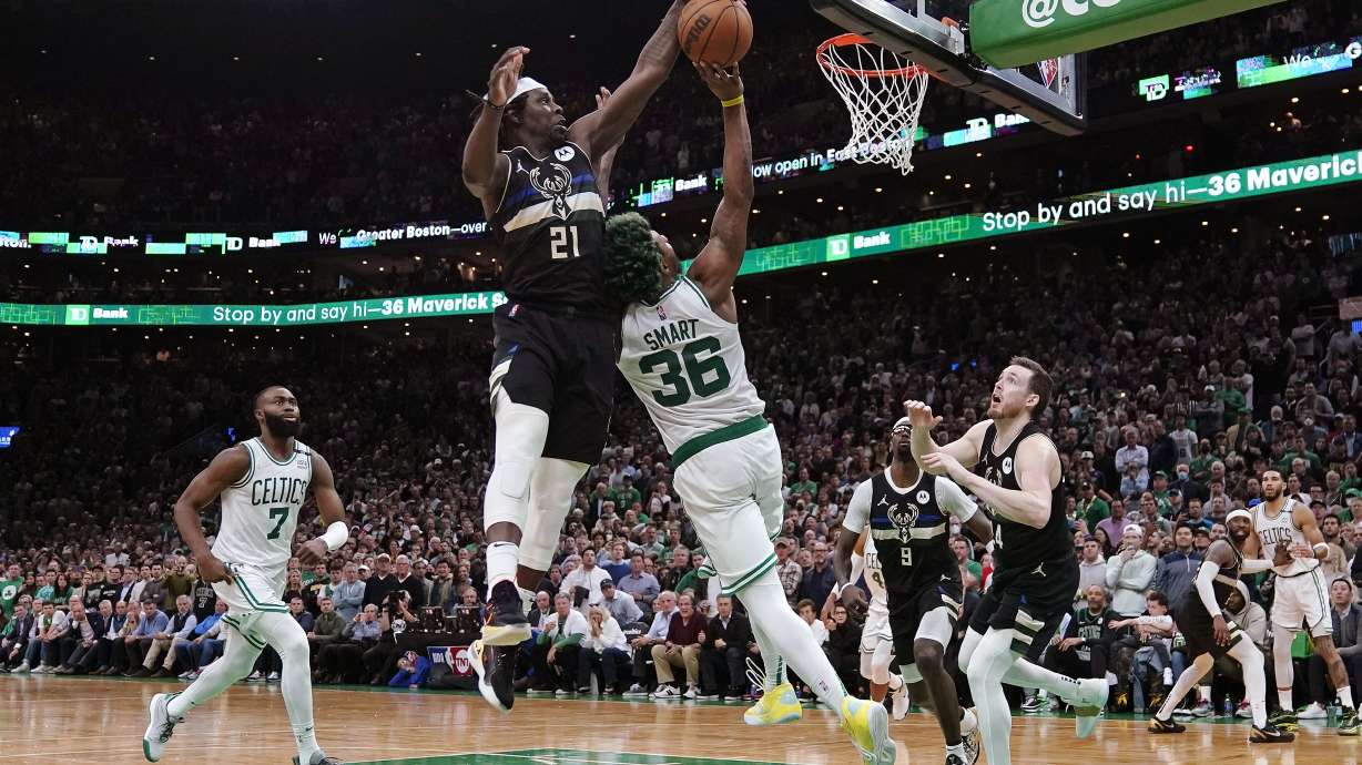 Milwaukee Bucks guard Jrue Holiday (21) blocks a shot by Boston Celtics guard Marcus Smart (36) in the final seconds of play during the second half of Game 5 of an Eastern Conference semifinal in the NBA basketball playoffs, Wednesday, May 11, 2022, in Boston. The Bucks won 110-107.