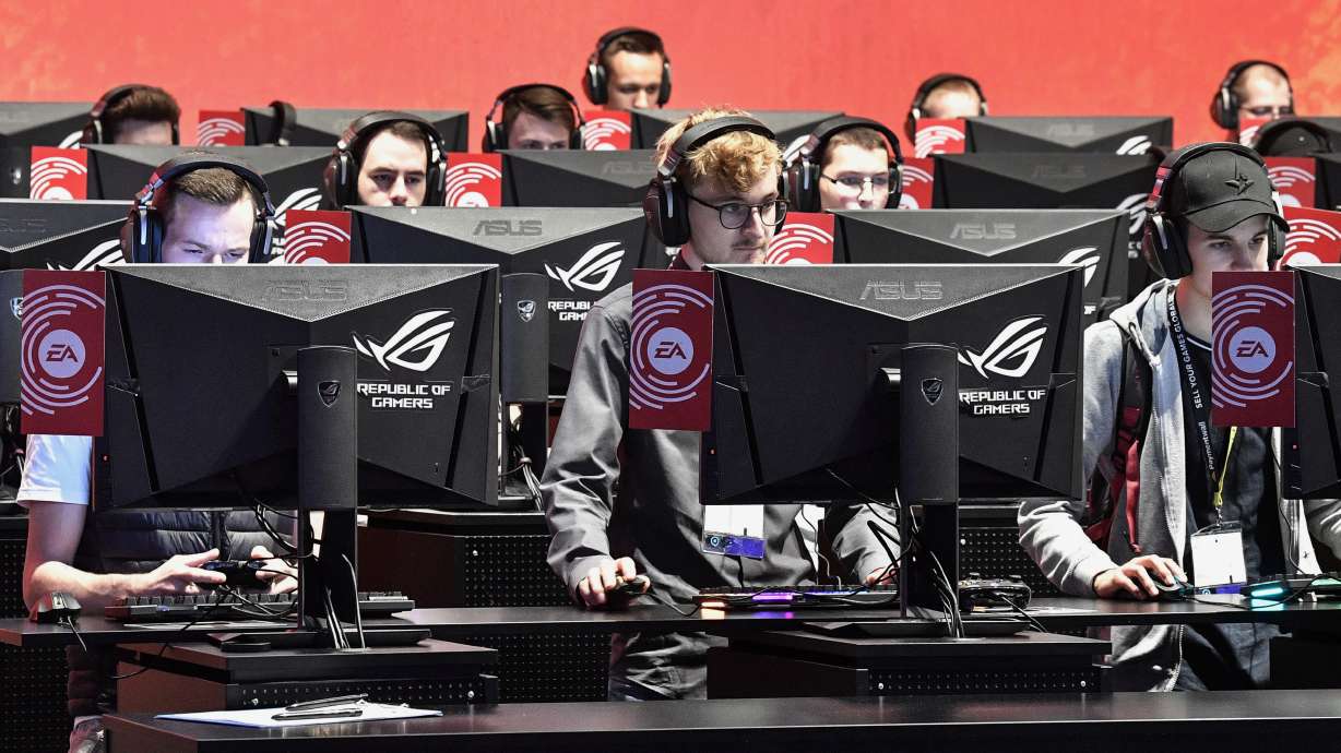 FILE - In this Aug. 20, 2019 file photo, gamers play latest video games from Electronic Arts at the Gamescom in Cologne, Germany. For three decades, the Zurich-based organizers of soccer have enjoyed a flourishing, mutually beneficial relationship with EA Sports producing annual edition of the FIFA game, alongside related products, and raking in billions of dollars. It so lucrative that FIFA thinks, it can be making even more cash. Now they are becoming opponents.