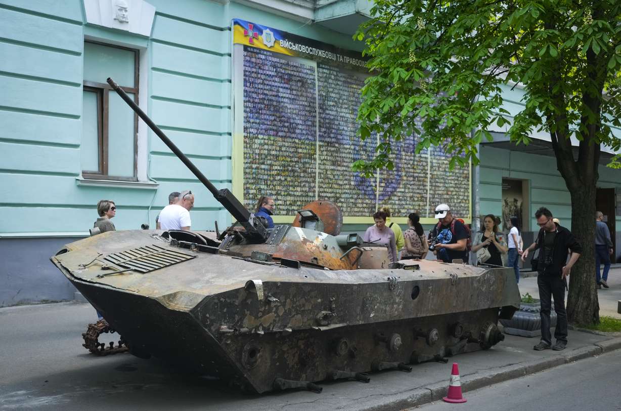People look at a Russian military vehicle destroyed by the Ukrainian troops in a battle against the Russian invaders and taken to the capital as a reminder of war in Kyiv, Ukraine, Thursday.
