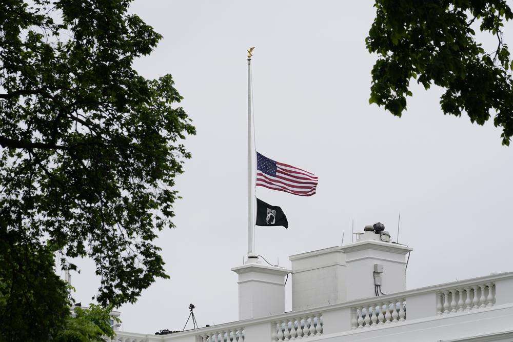 The American flag flies at half-staff at the White House in Washington, Thursday as the Biden administration commemorates 1 million American lives lost due to COVID-19.