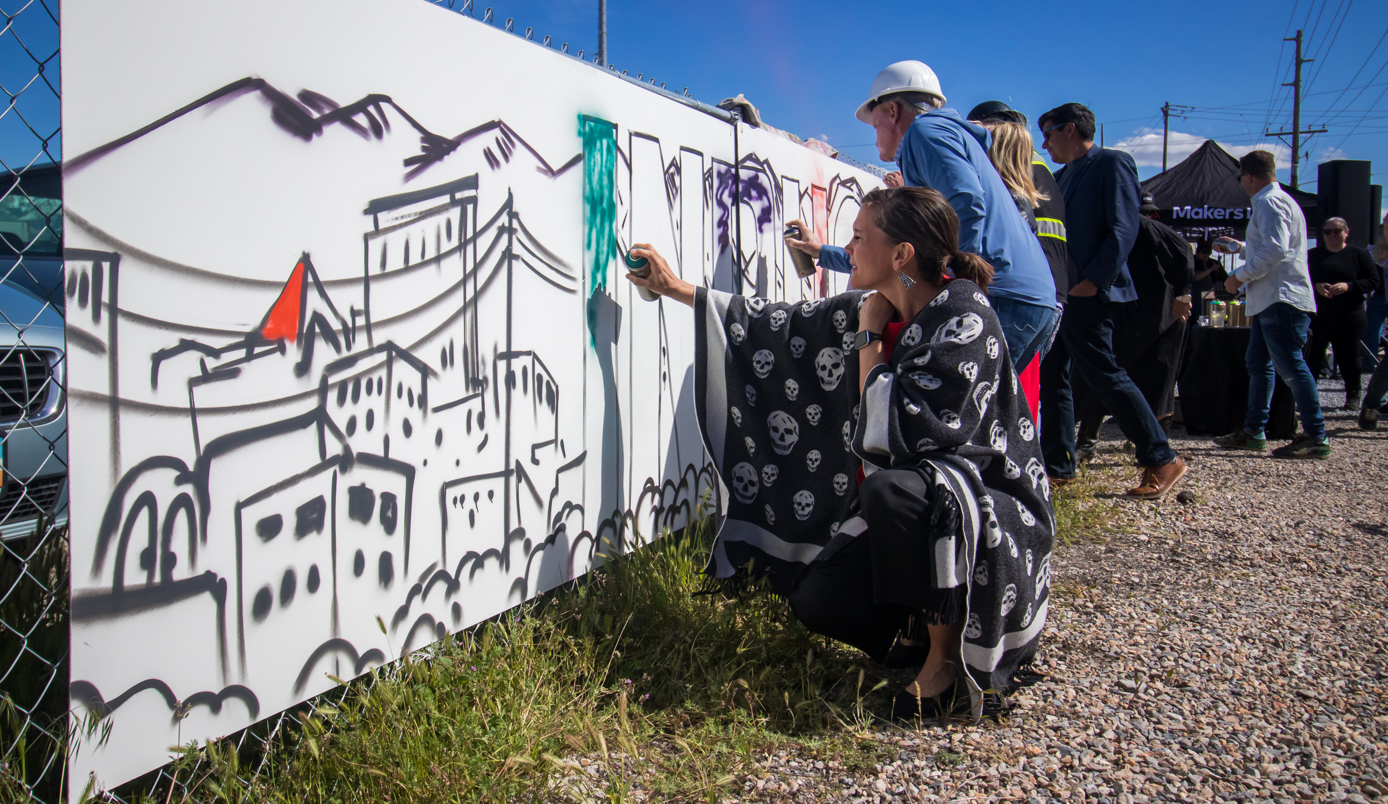Salt Lake City Mayor Erin Mendenhall joins business executives, employees and others Thursday in painting a mural in a space that will be home to a new parking garage in the Granary District.