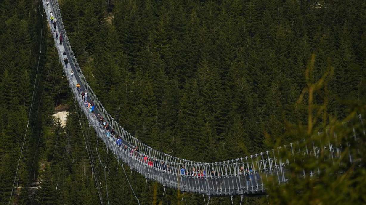 Visitors cross a suspension bridge for the pedestrians that is the longest bridge of its type in the world, in Dolni Morava, Czech Republic, Friday.