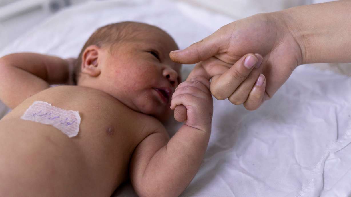 A newborn baby holds on a nurse's finger at the maternity ward of the children hospital in Kabul, Afghanistan, Oct. 24, 2021. Australian researchers say they've identified one potential biomarker for sudden infant death syndrome, known as SIDS, but experts caution that it's just one piece of the puzzle.