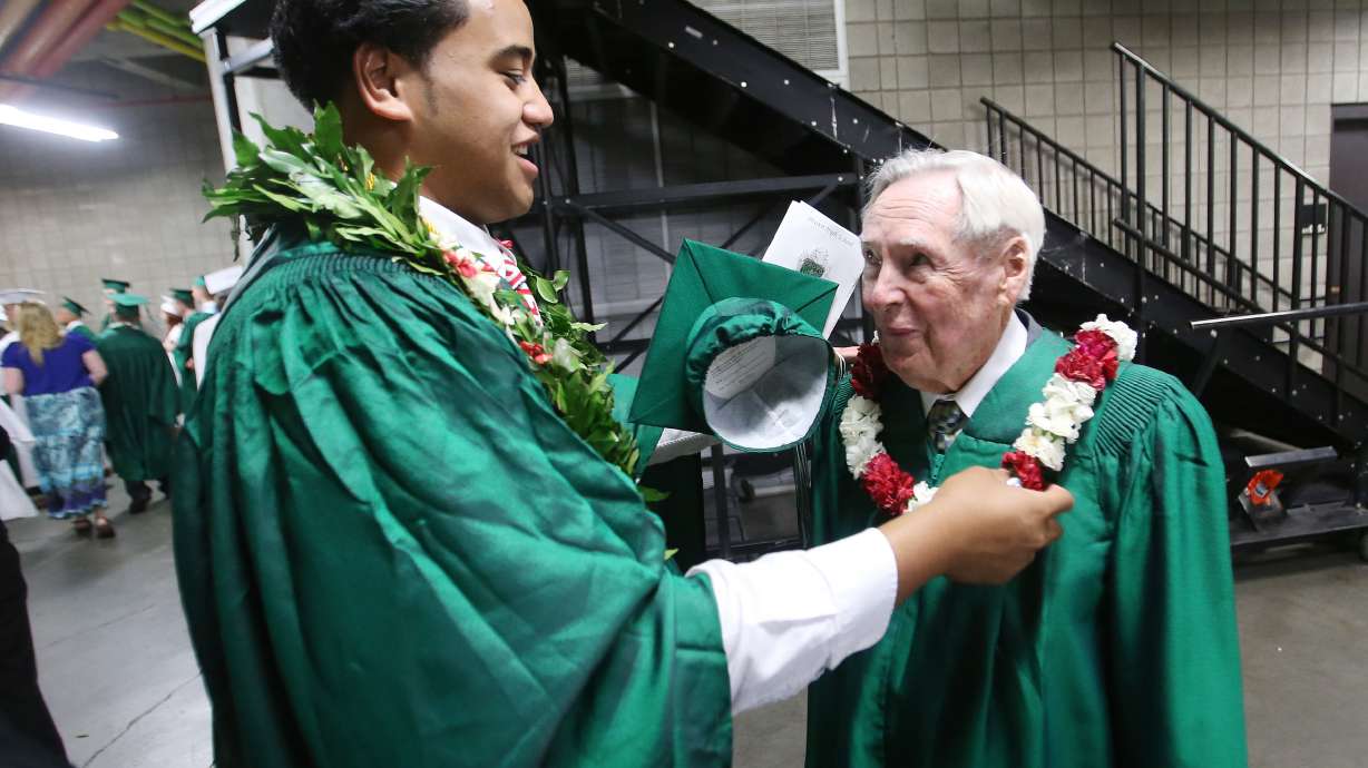 Provo High student body president George Ngatuvai gives Jackson Howard a lei prior to walking with fellow Provo High graduates at Utah Valley University in Orem on May 29, 2013. Howard left high school 6 months prior to graduation in 1943 to fight in World War II.