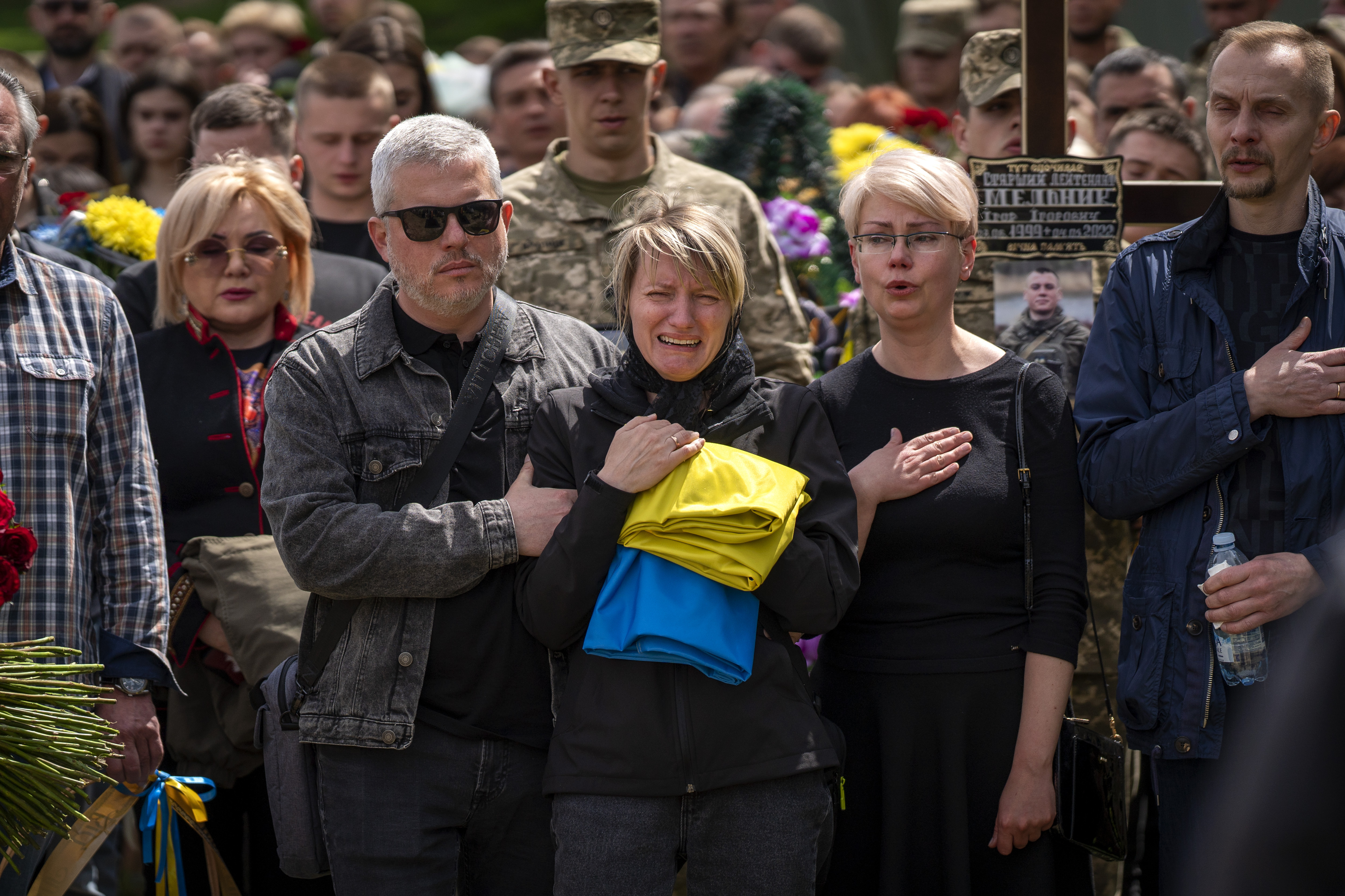 Natalia Pohoreltseva, mourns next to the grave of her soon Melnyk Andriy, 23, a Ukrainian military servicemen who was killed in Kharkiv province, during his funeral in Lviv, Ukraine, Saturday.