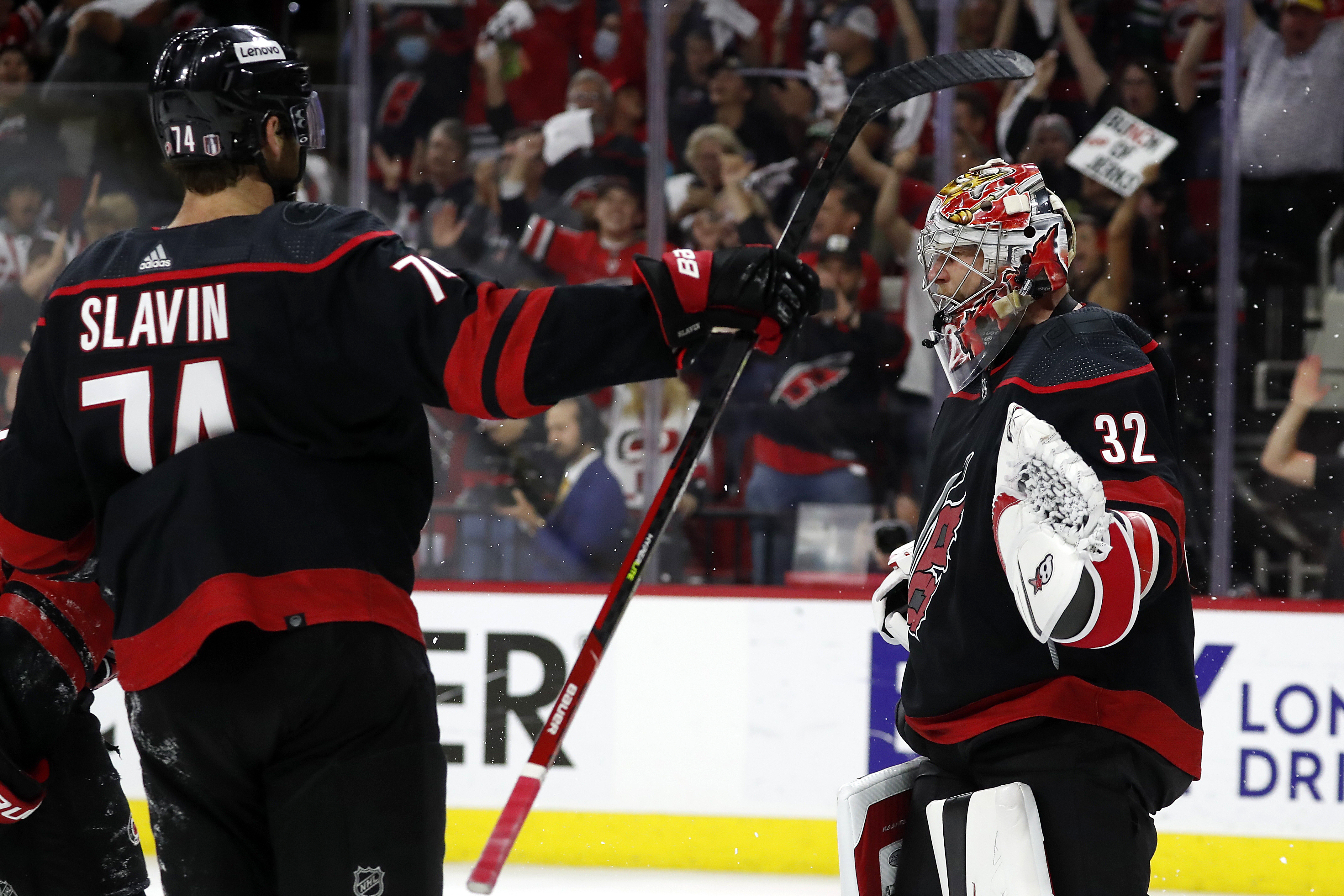 Carolina Hurricanes goaltender Antti Raanta (32) celebrates with teammate Jaccob Slavin (74) following their win over the Boston Bruins in Game 7 of an NHL hockey Stanley Cup first-round playoff series in Raleigh, N.C., Saturday, May 14, 2022. 