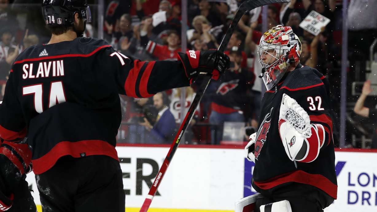 Carolina Hurricanes goaltender Antti Raanta (32) celebrates with teammate Jaccob Slavin (74) following their win over the Boston Bruins in Game 7 of an NHL hockey Stanley Cup first-round playoff series in Raleigh, N.C., Saturday, May 14, 2022.