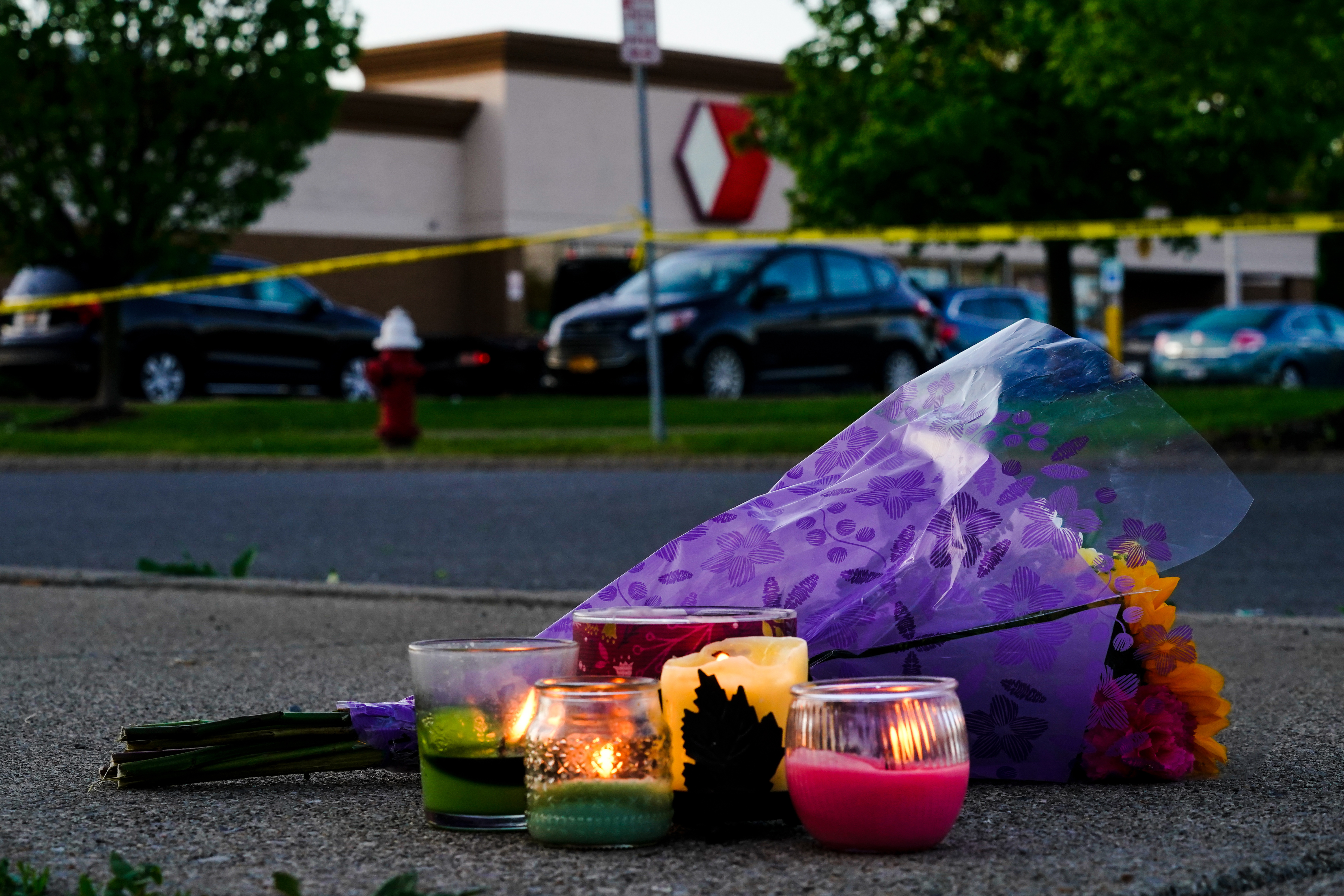 Flowers and candles lay outside the scene of a shooting at a supermarket, in Buffalo, N.Y., Sunday.