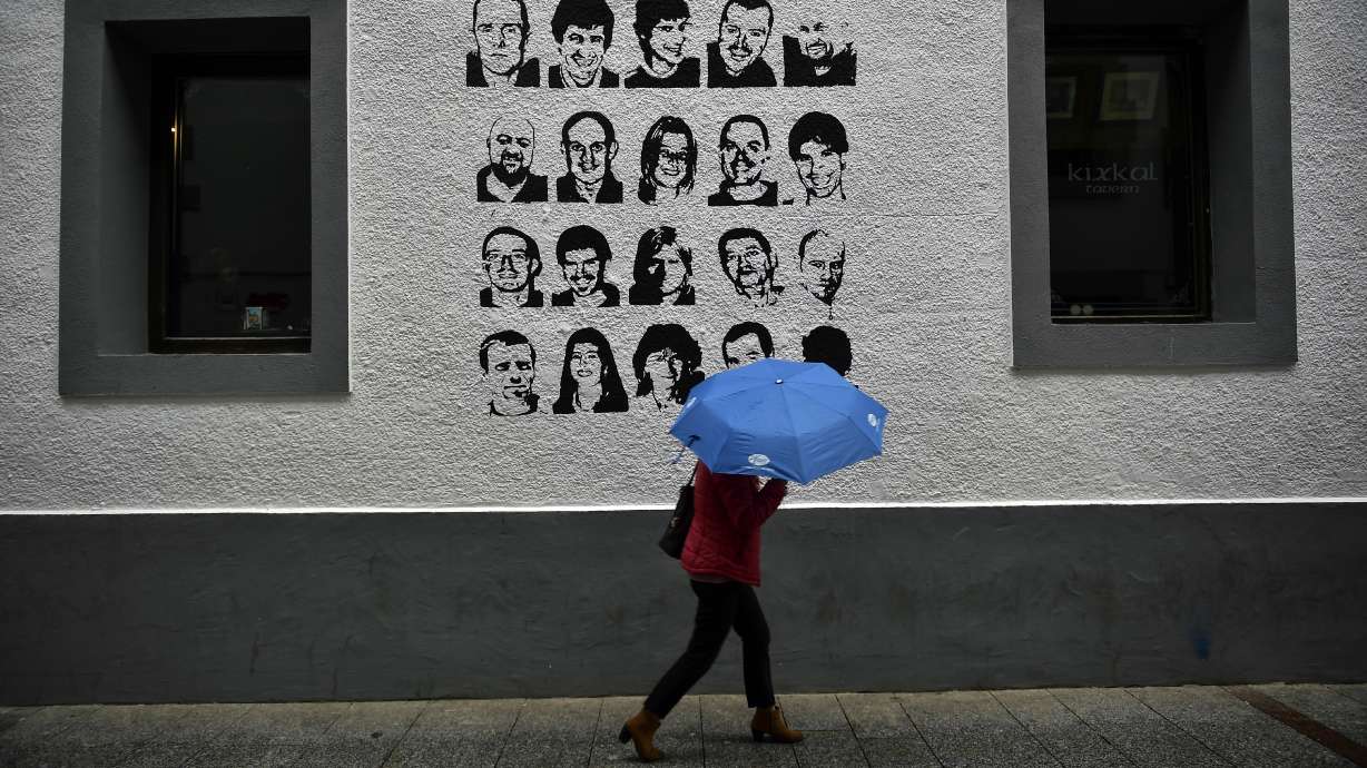A woman shelters from the rain under an umbrella, while walking past a wall painted with portraits of prisoners of the Basque separatist armed group ETA, in the small village of Hernani, northern Spain, May 2, 2018. The United States is poised to remove five extremist groups, all believed to be defunct, from its list of foreign terrorist organizations.