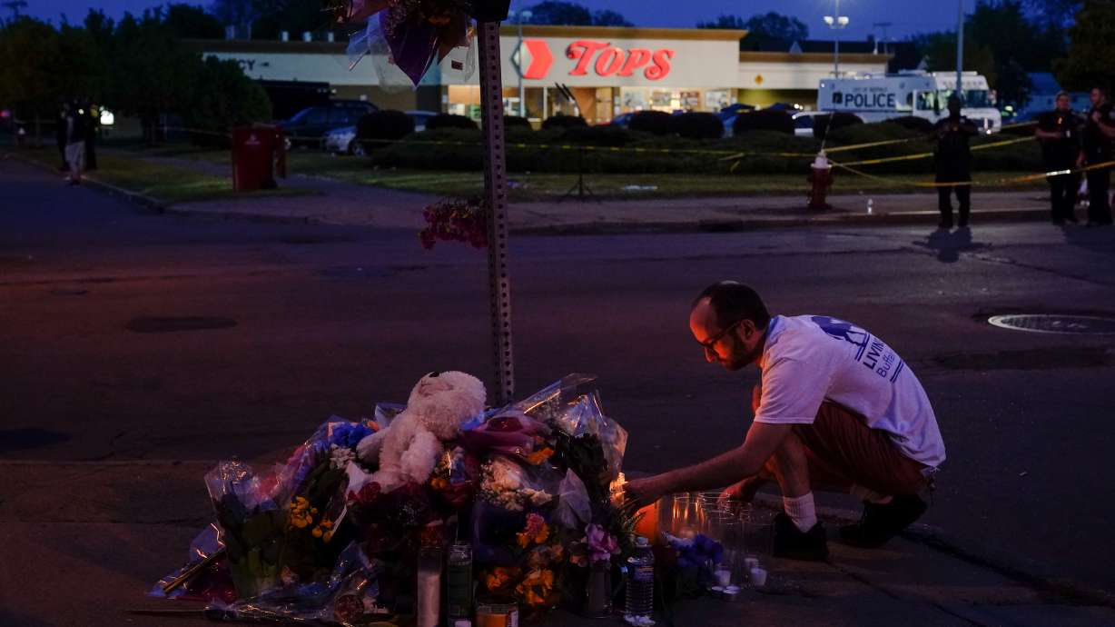 A person pays his respects outside the scene of a shooting at a supermarket, in Buffalo, N.Y., Sunday, May 15, 2022.