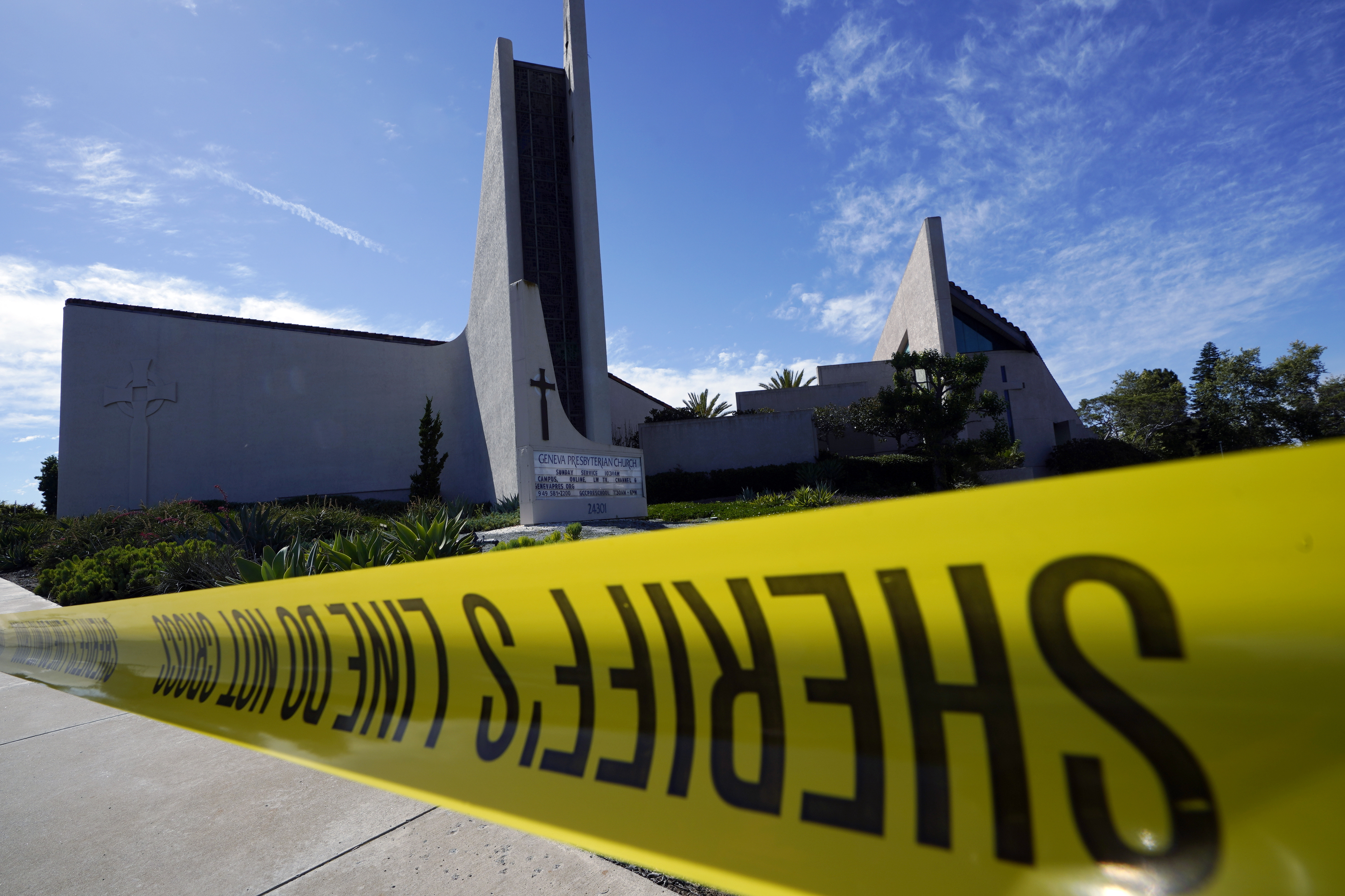Crime scene tape is stretched across an area at Geneva Presbyterian Church in Laguna Woods, Calif., Sunday after a fatal shooting. Worshippers detained the alleged shooter by hog-tying his legs with an electrical cord until authorities arrived.