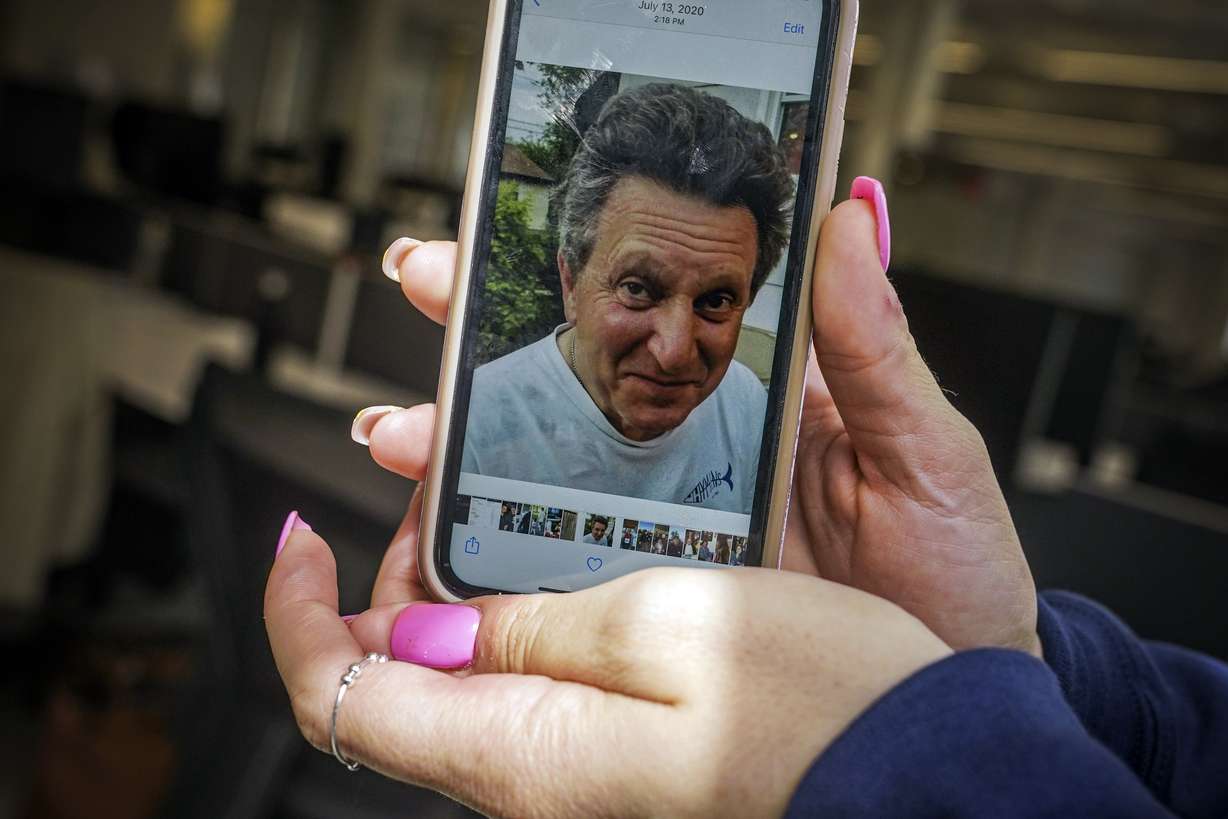 Angelina Proia on Wednesday in New York, shows a photo of her father Richard Proia, who died of COVID-19 in April 2020.