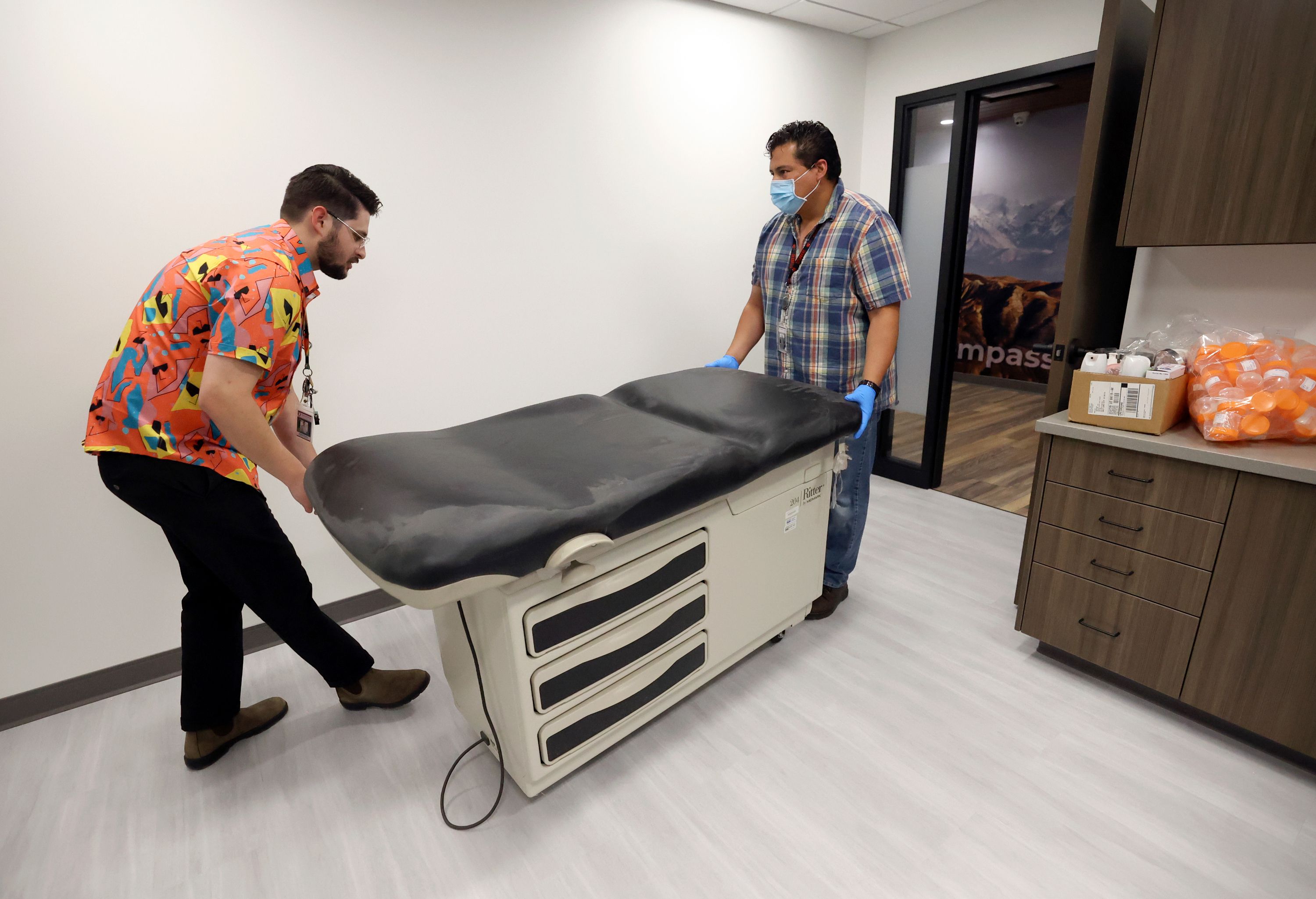 Andrew Grover, Sacred Circle Healthcare marketing specialist, and Diego Arellano, Sacred Circle Healthcare IT support, move a bed into an exam room that will be used for medical substance abuse treatment at Sacred Circle Healthcare’s new substance abuse clinic in Salt Lake City on May 11.